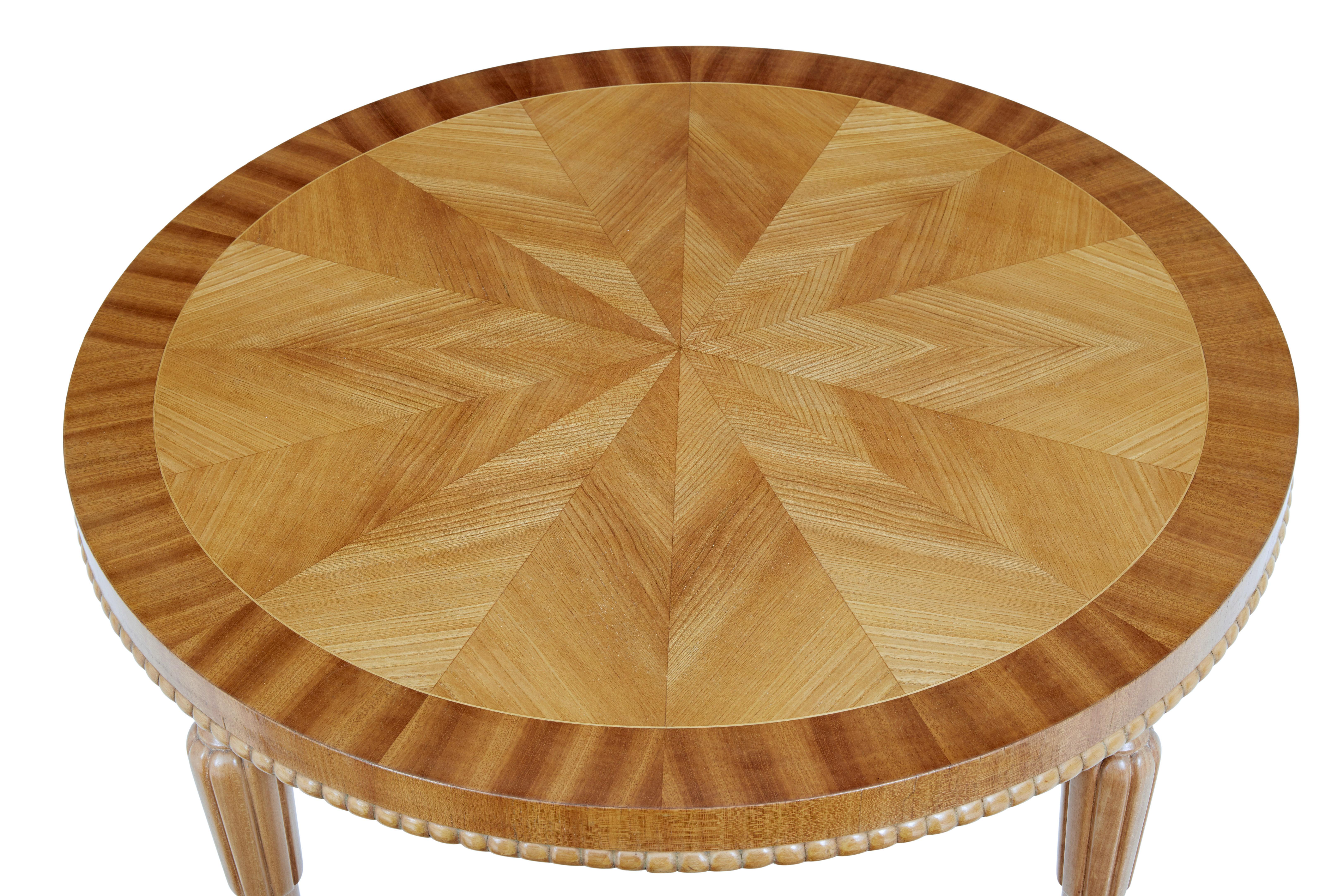 Scandinavian mid 20th century elm round coffee table circa 1950.

Round top with segmented elm veneer centre and stringing in between an outer mahogany border. Beaded detail below the apron. Standing on tapered legs with fluted detail.

Very