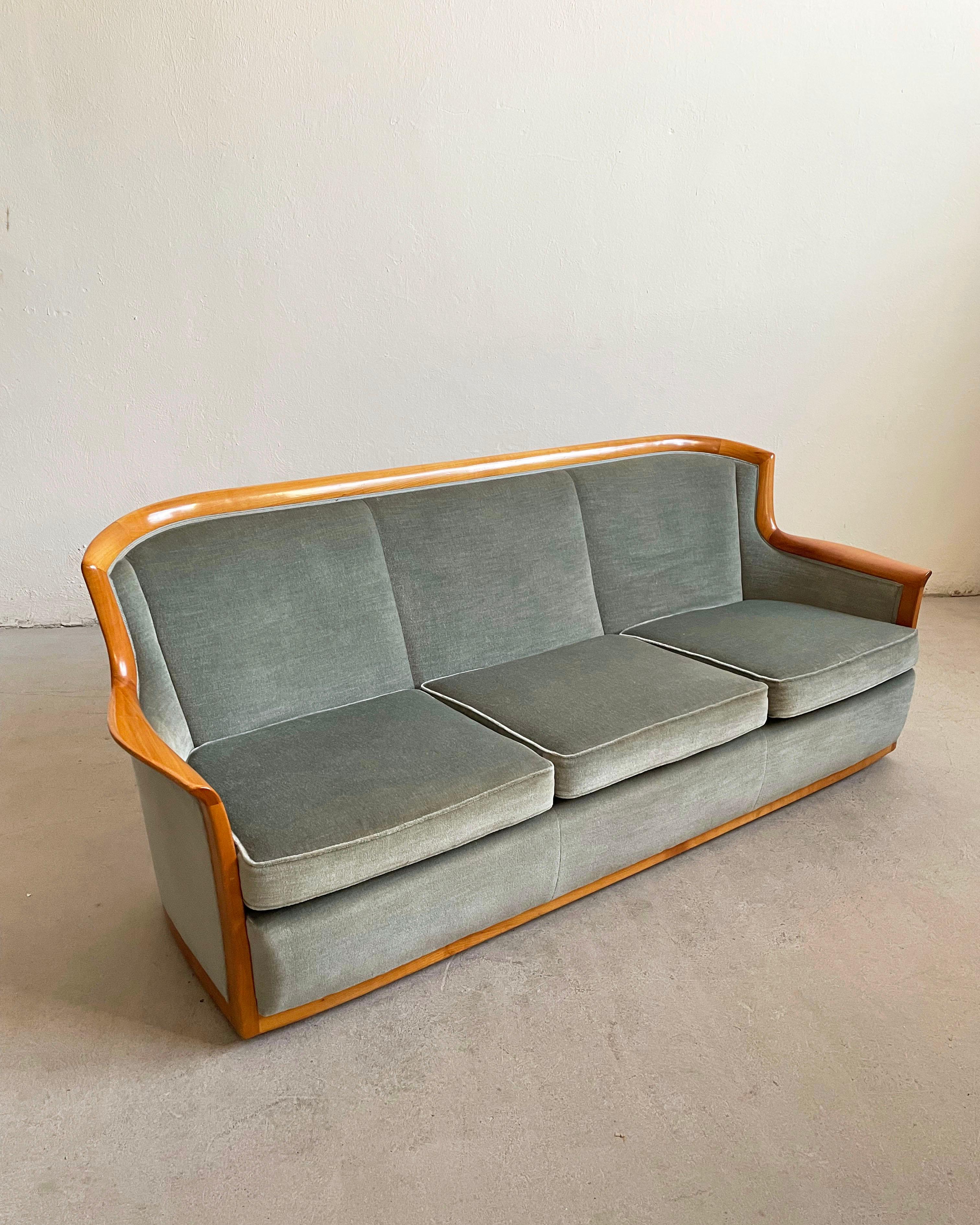Vintage Scandinavian Mid-century living room from the 1960s.

The seating group consists of a 3-seater sofa and two arm chairs with curved backs, in original blue gray velvet upholstery, standing on metal casters, and having a solid cherry wood trim