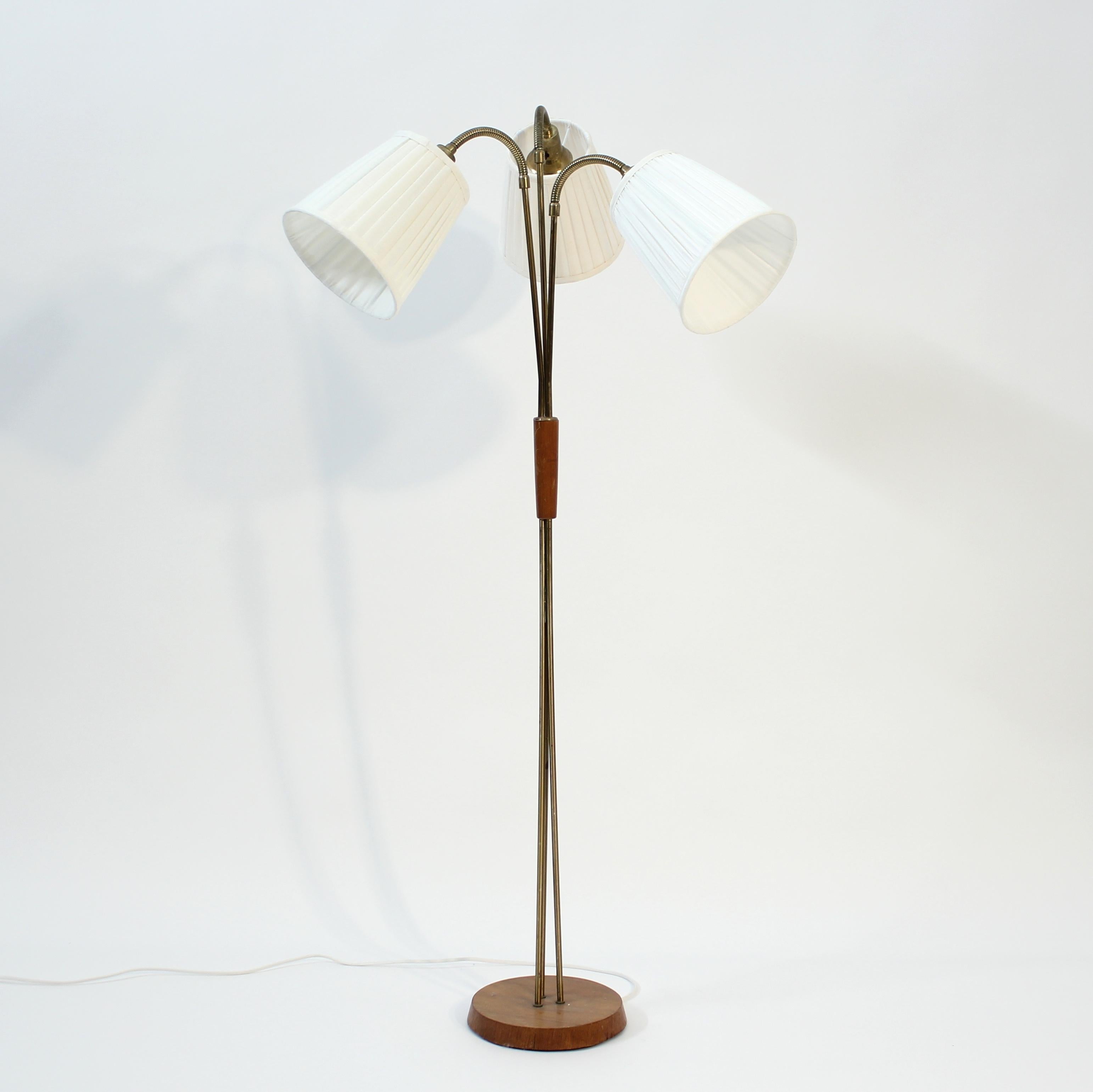 Swedish mid-century floor lamp with three adjustable swan neck light sources, mounted on three different heights. Brass stem with brass details. Fitted with three new pleated white shades. Good and honest vintage condition with light ware consistent