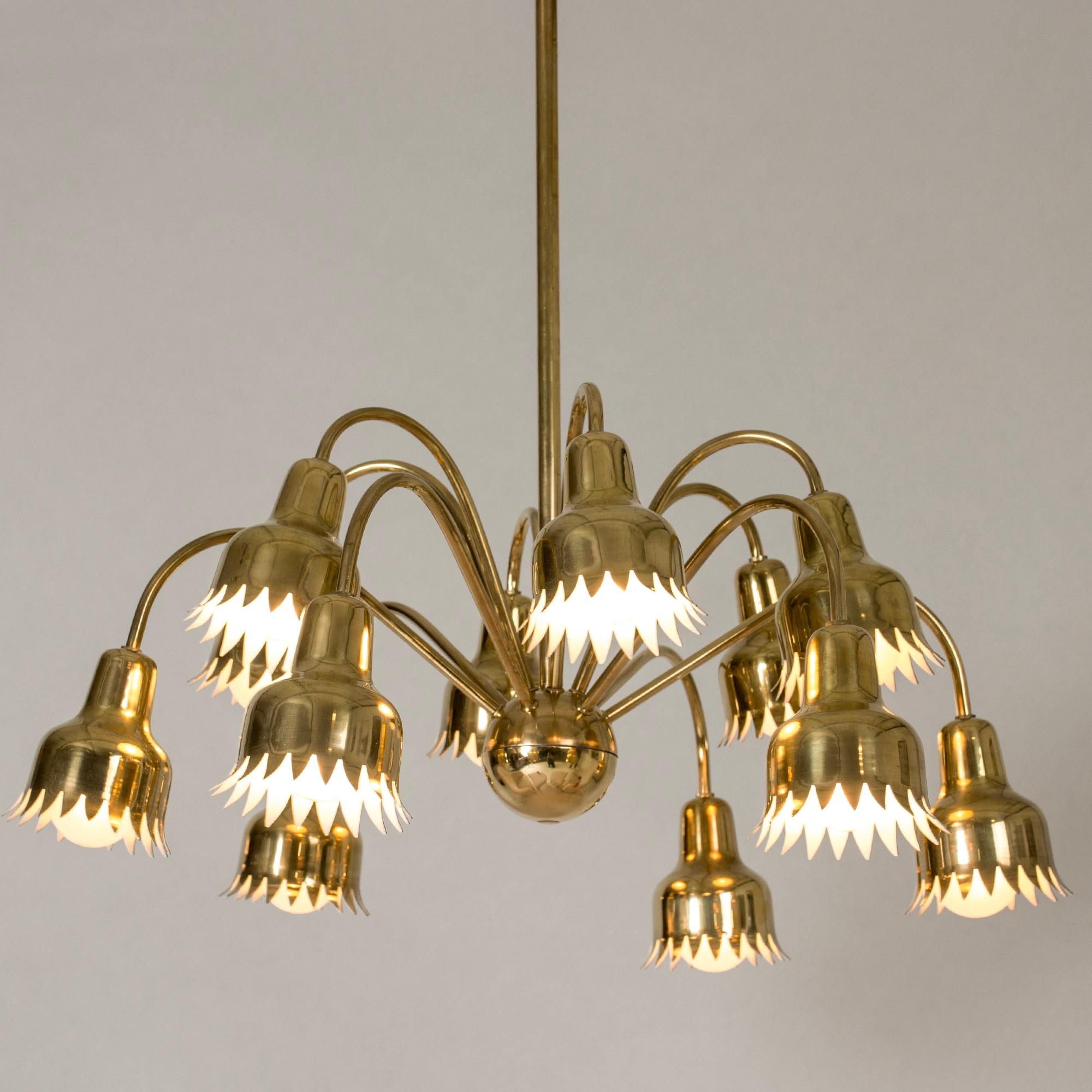 Stunning brass chandelier by Hans Bergström. Twelve curved arms extend from a central brass ball, with zigzag edged, flowerlike shades. A beautiful, embellished modernist piece.

Hans Bergström was the owner and creative director of the lighting