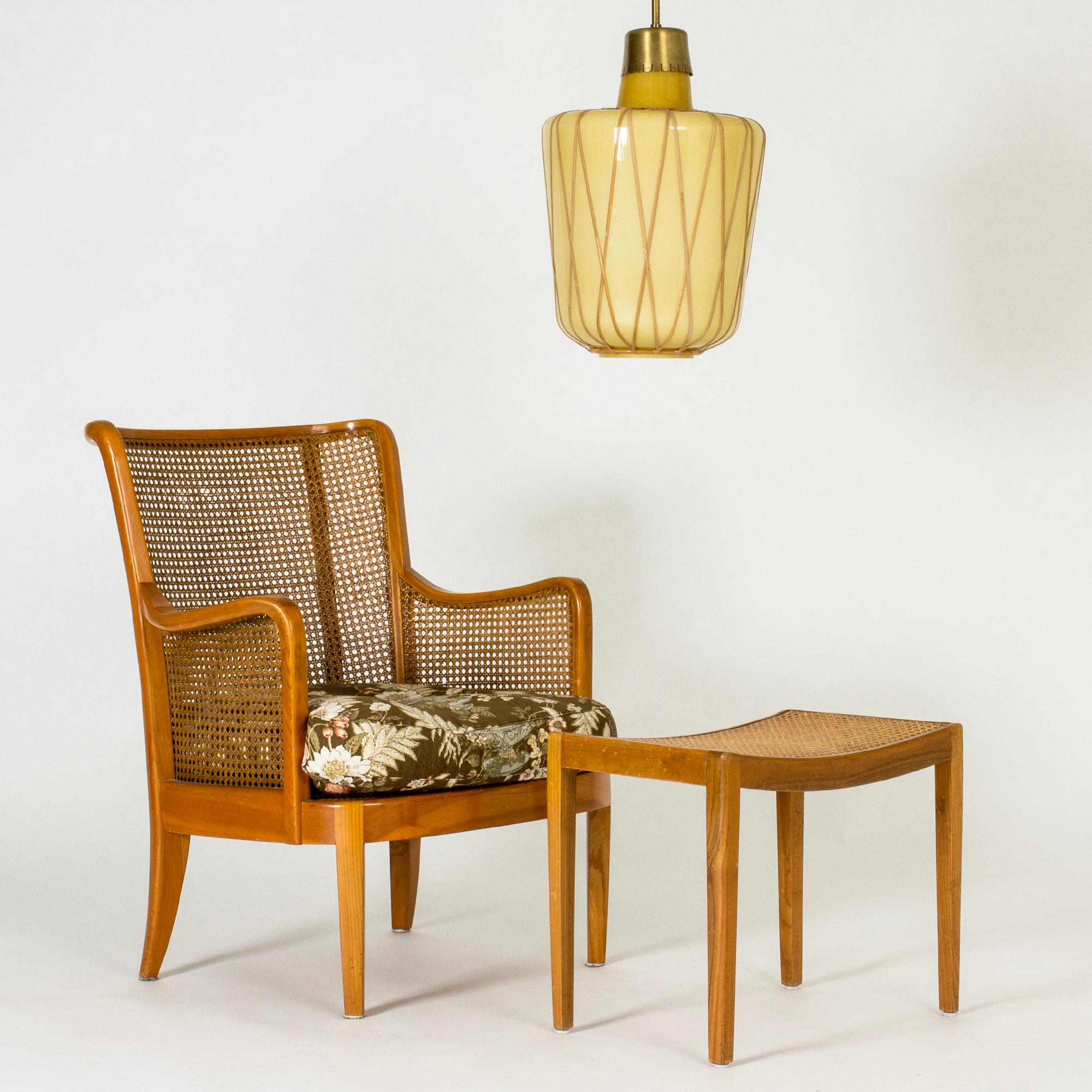 Striking Swedish Modern ceiling light by Bo Notini, with a large yellow tinted glass shade decorated with rattan strands in a graphic pattern. Brass stem and ceiling cup.