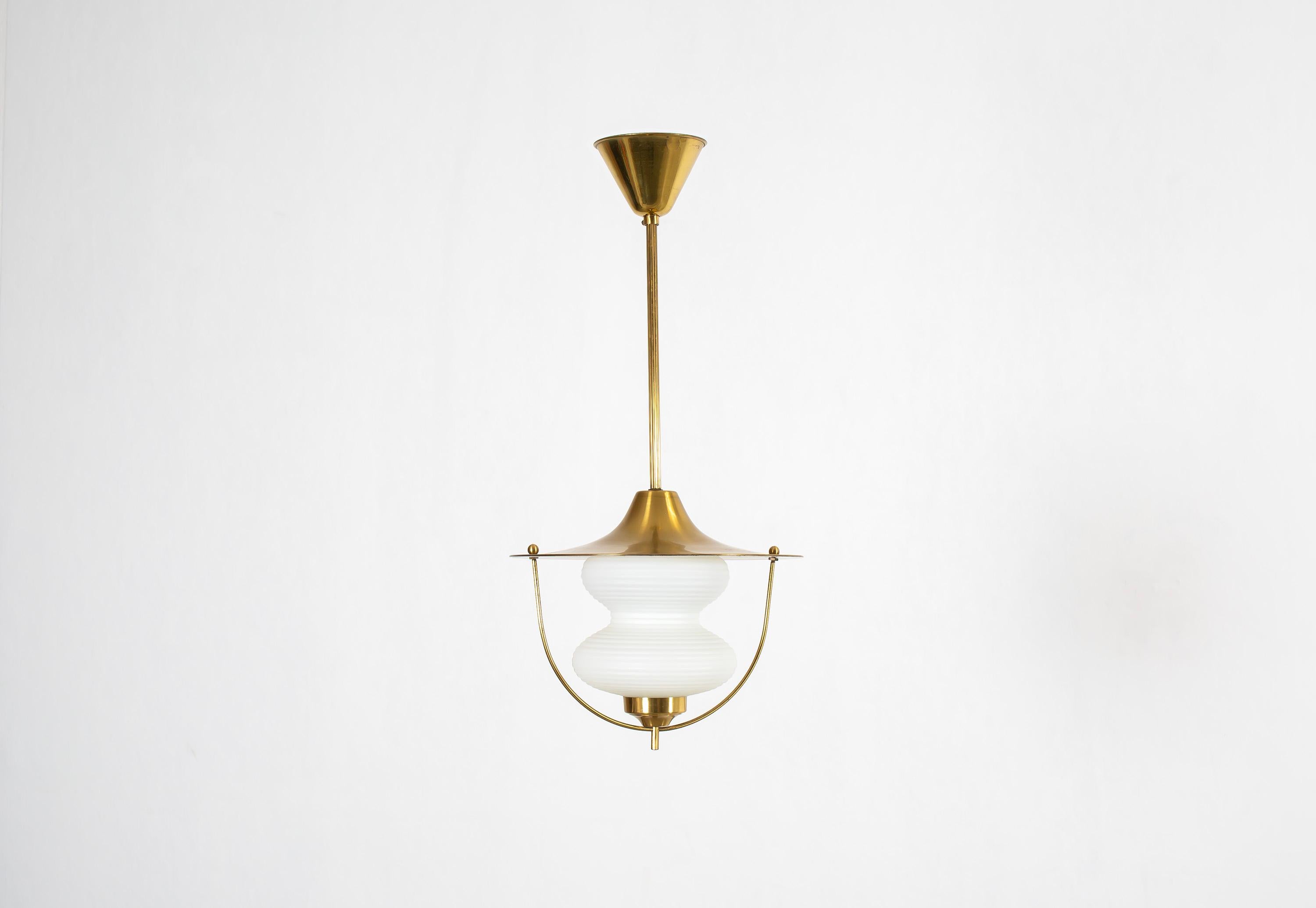 Modernist ceiling light in brass with a shade in opaline glass. Designed and made in Norway from cirka 1960s first half. The lamp is fully working and in good vintage condition. It is fitted with one E27 bulb holder (works in the US), with a max