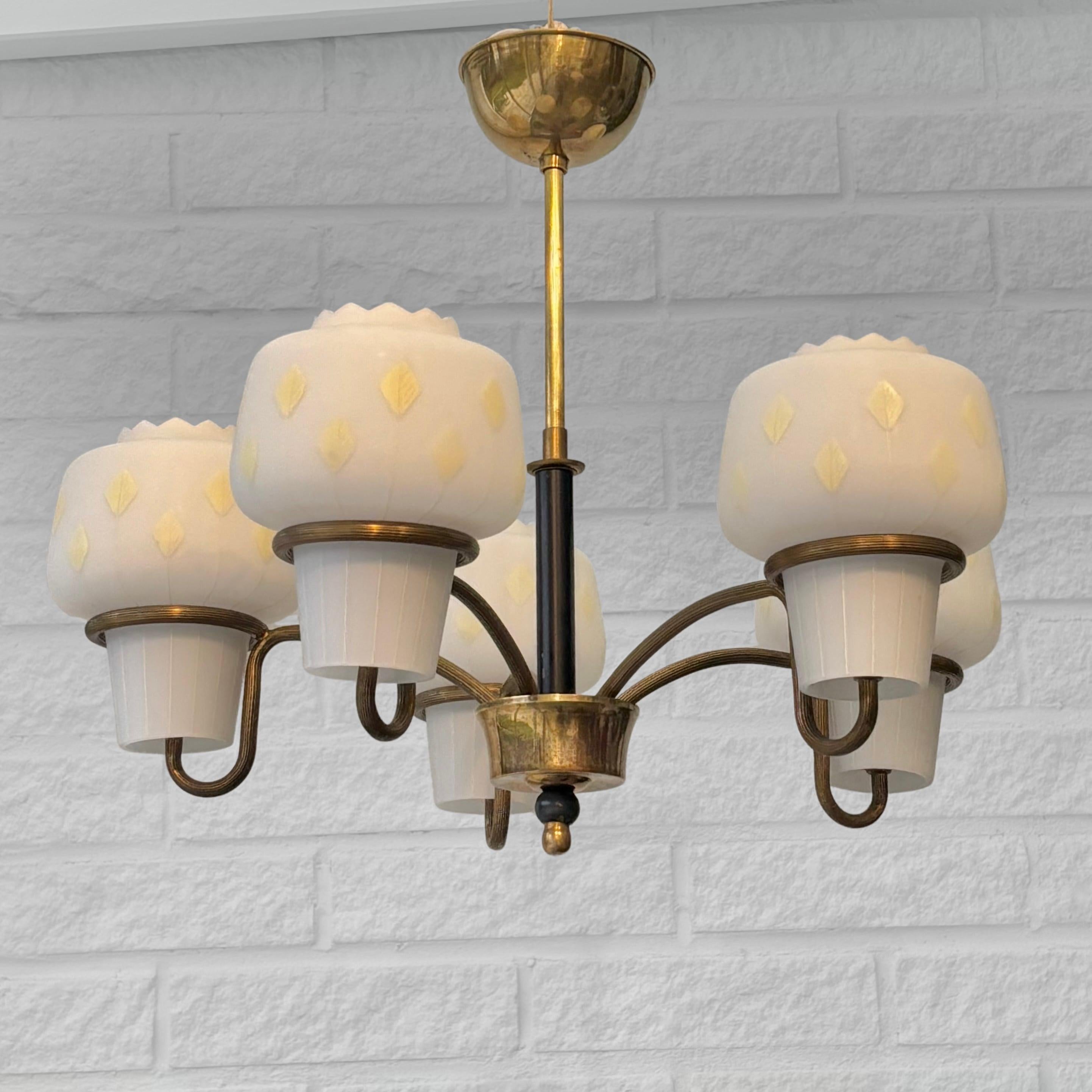 Lampadario scandinavo di metà secolo, prodotto da un produttore svedese non identificato negli anni '50. Realizzato in ottone con cinque bracci curvi che si irradiano da un centro in ottone. Ogni braccio sostiene un paralume in vetro originale