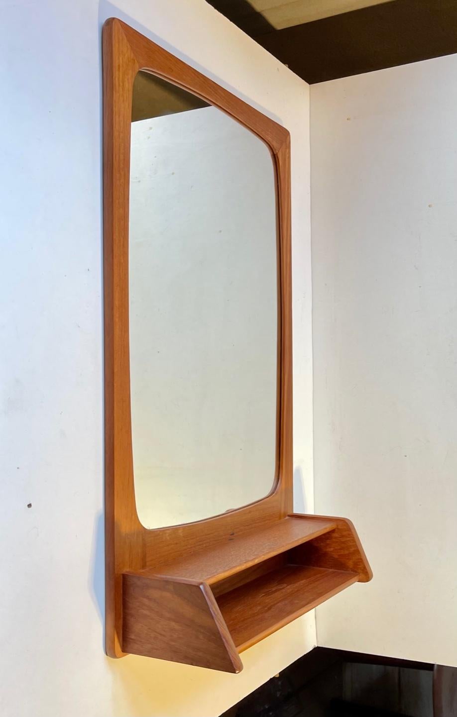 Small well made framed wall mirror with underlying shelf in teak. Practical in your entrance hall or wardrobe. Manufactured in Scandinavia/Denmark during the 1960s by an anonymous cabinet maker. Measurements: 53.3 x 32.5 cm.