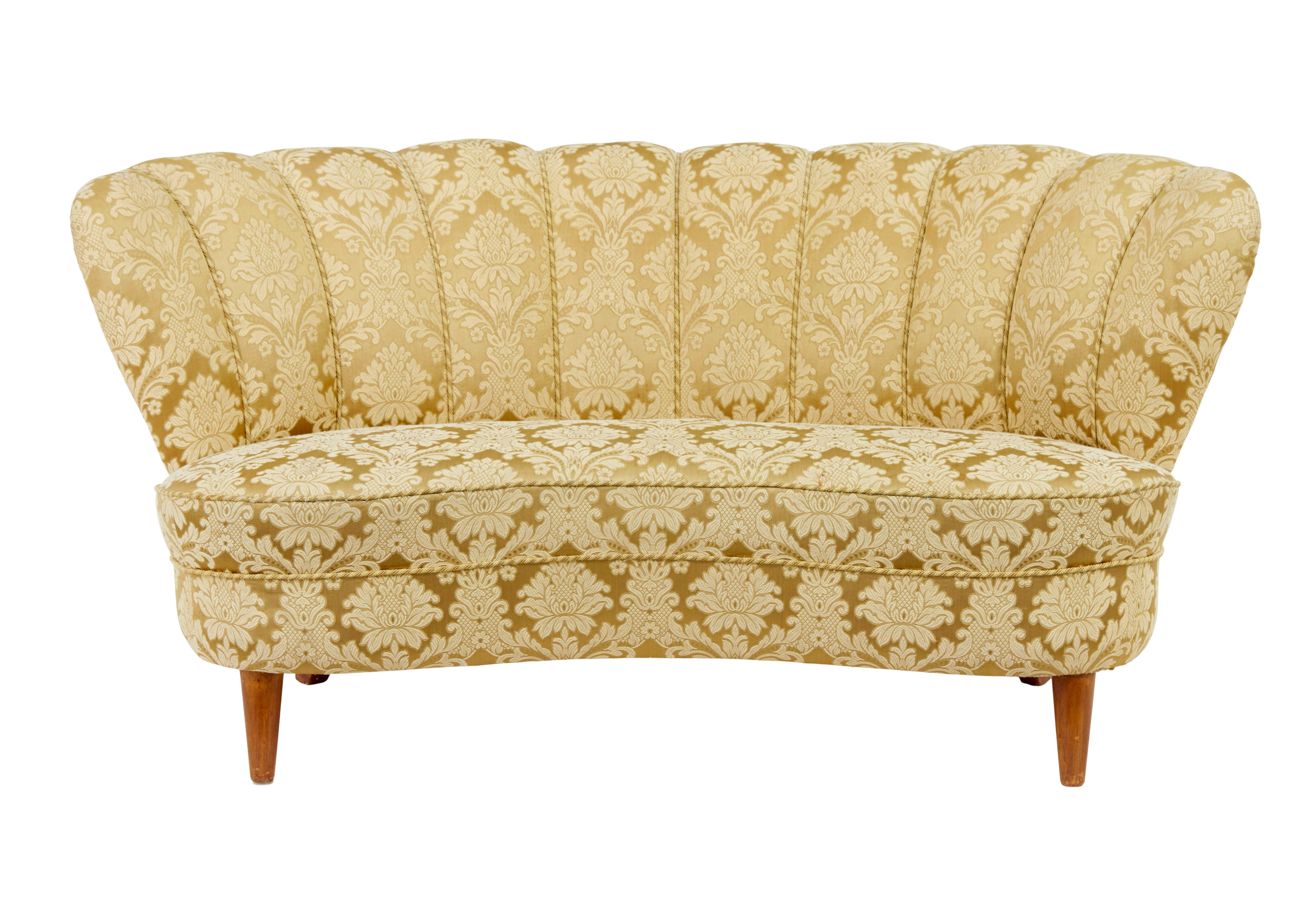 3 piece mid 20th century shell back living room suite circa 1950.

Elegant lounge suite to give any interior that hotel look and very much in the art deco taste. Concave seats with shell back back rests, complete with piping detail.  Golden fabric