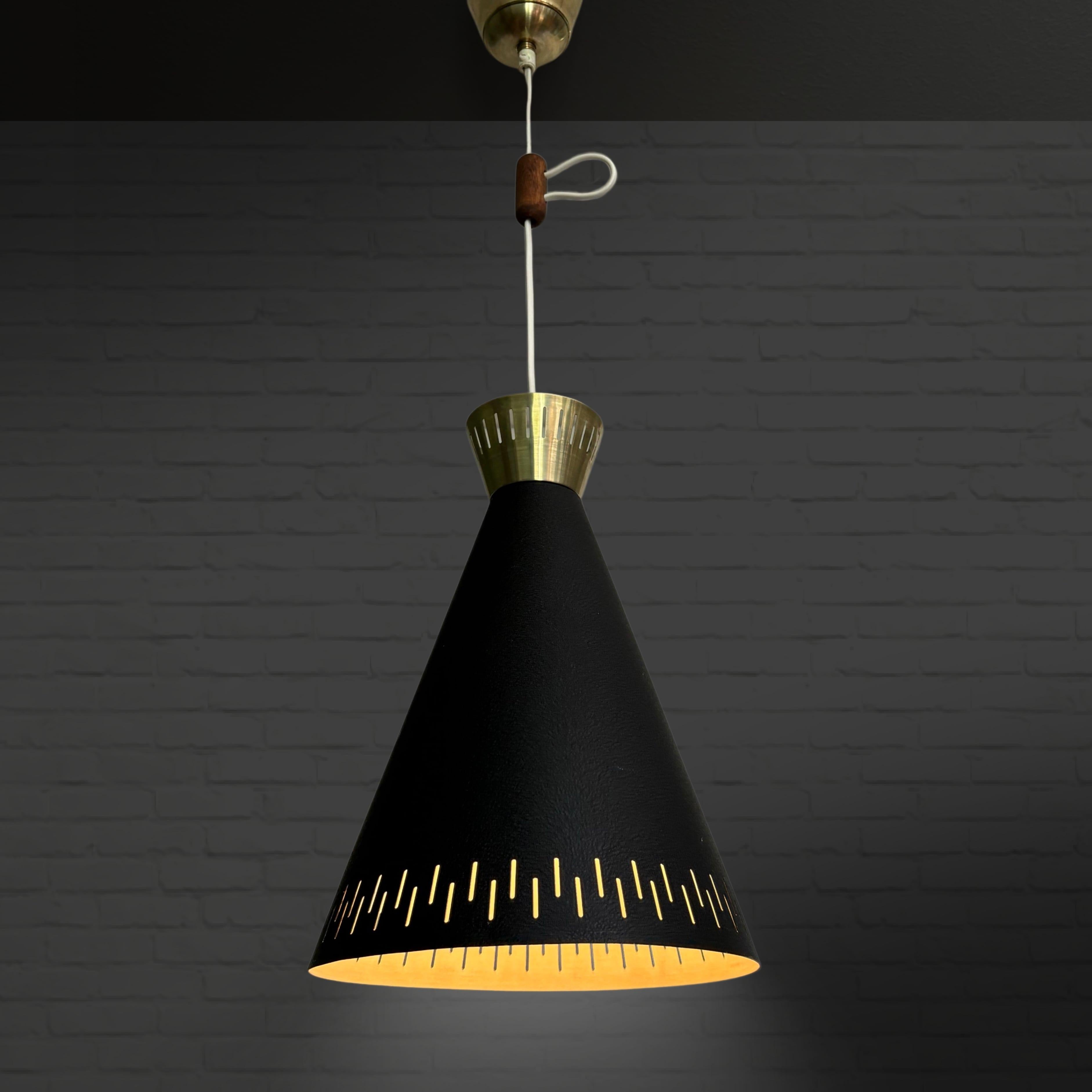 Un'elegante lampada a sospensione a doppio cono della metà del secolo scorso, prodotta da un produttore svedese non identificato negli anni Cinquanta. Realizzato in alluminio e ottone con un motivo geometrico traforato. Il cavo è dotato di un