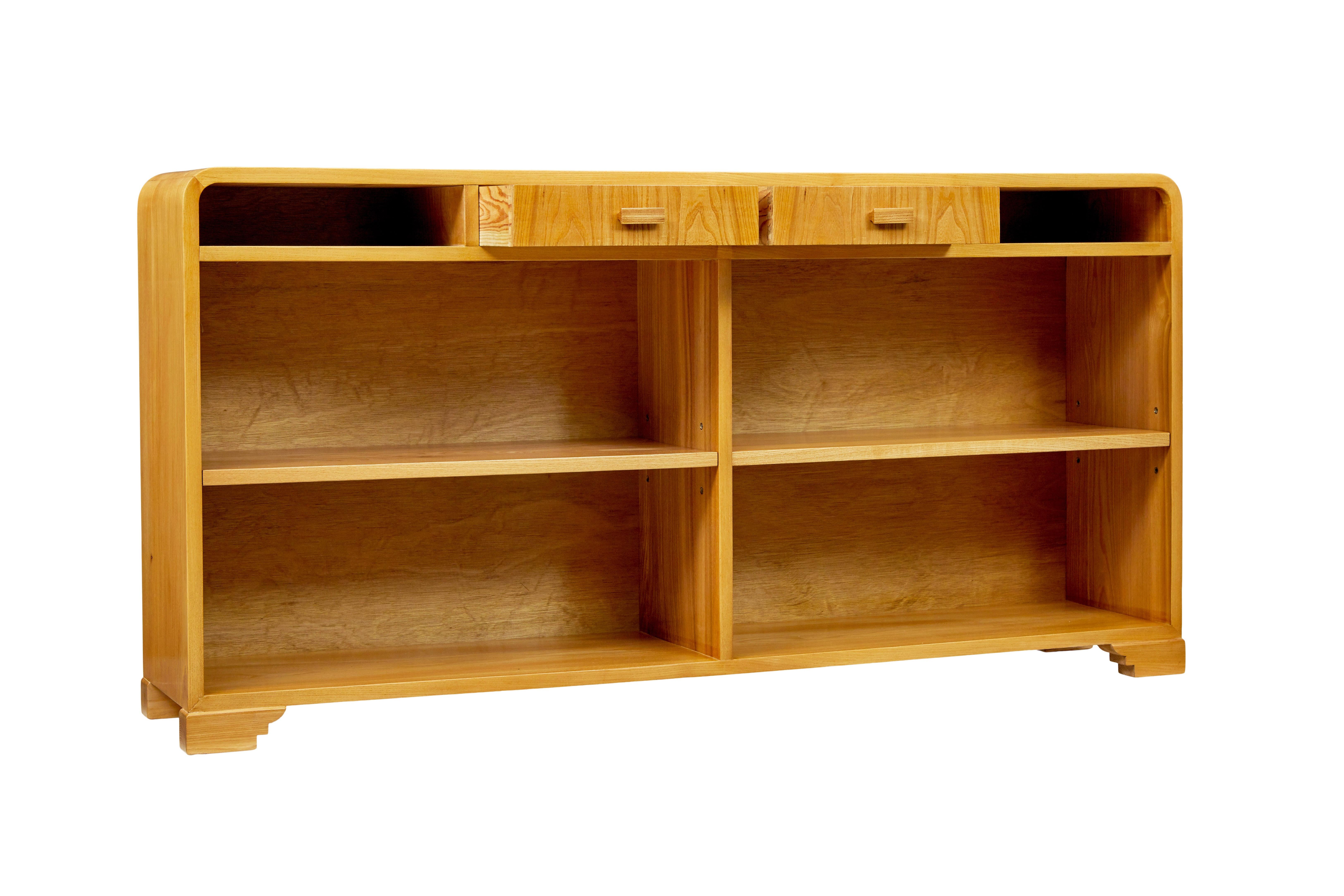Scandinavian mid century elm low open bookcase circa 1950.

Good quality shaped low sideboard/bookcase that offers plenty of storage without taking up loads of room.

Made in elm, which showcases it's striking grain.  Shaped ends.  2 drawers below