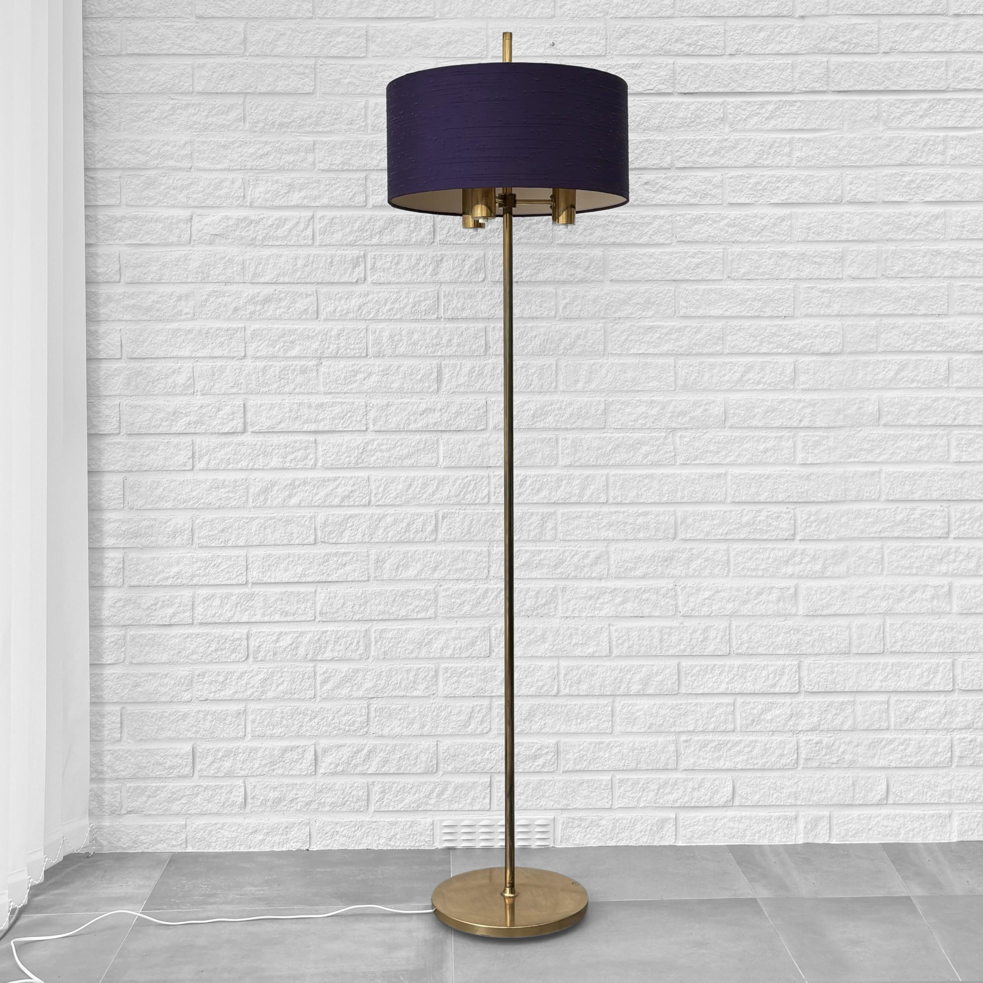 A rare Swedish mid-century floor lamp produced by the manufacturer Fagerhults Belysning in the 1960s. Made from brass with three lamp holders and a beautiful cylindrical shade upholstered in original purple textile. Each arm has an individual light