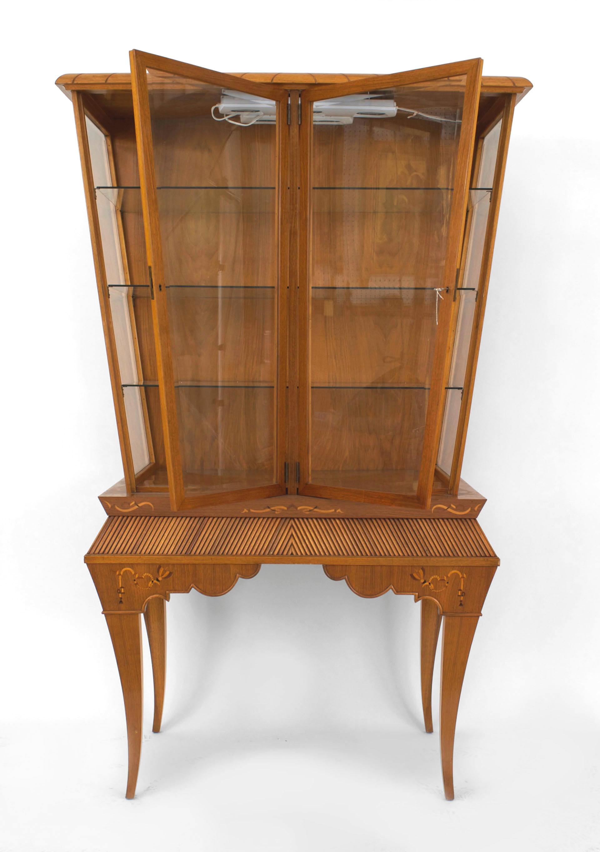 Scandinavian Mid-Century light mahogany display/vitrine cabinet with a keystone shaped top sections supported on a base with a fluted apron and inlaid floral design trim.
