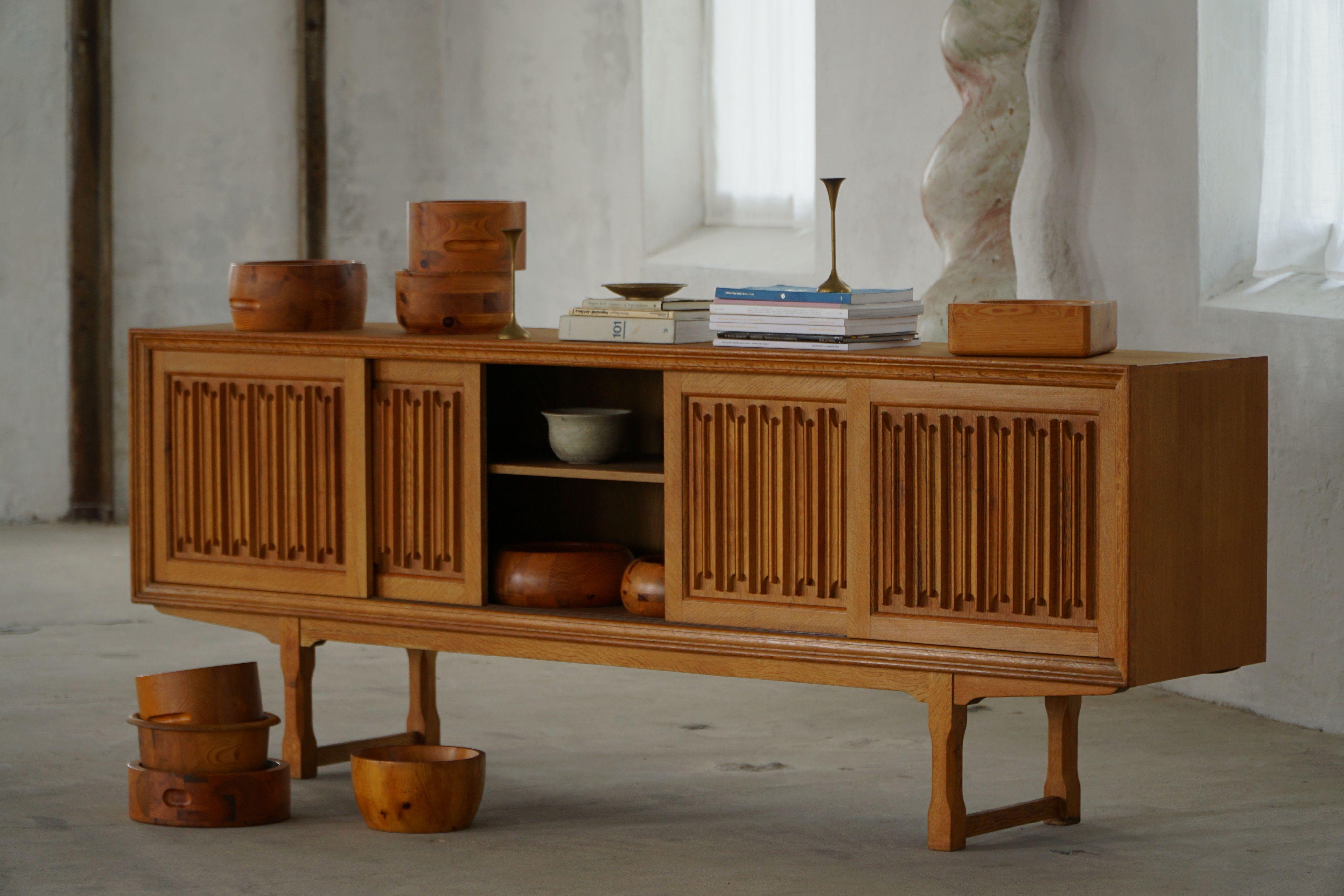Una classica credenza rettangolare in Oak con ampi spazi e un frontale elegantemente intagliato, realizzata da un ebanista danese negli anni Sessanta. Il design è caratterizzato da linee pulite abbinate a sottili dettagli decorativi, che mettono in