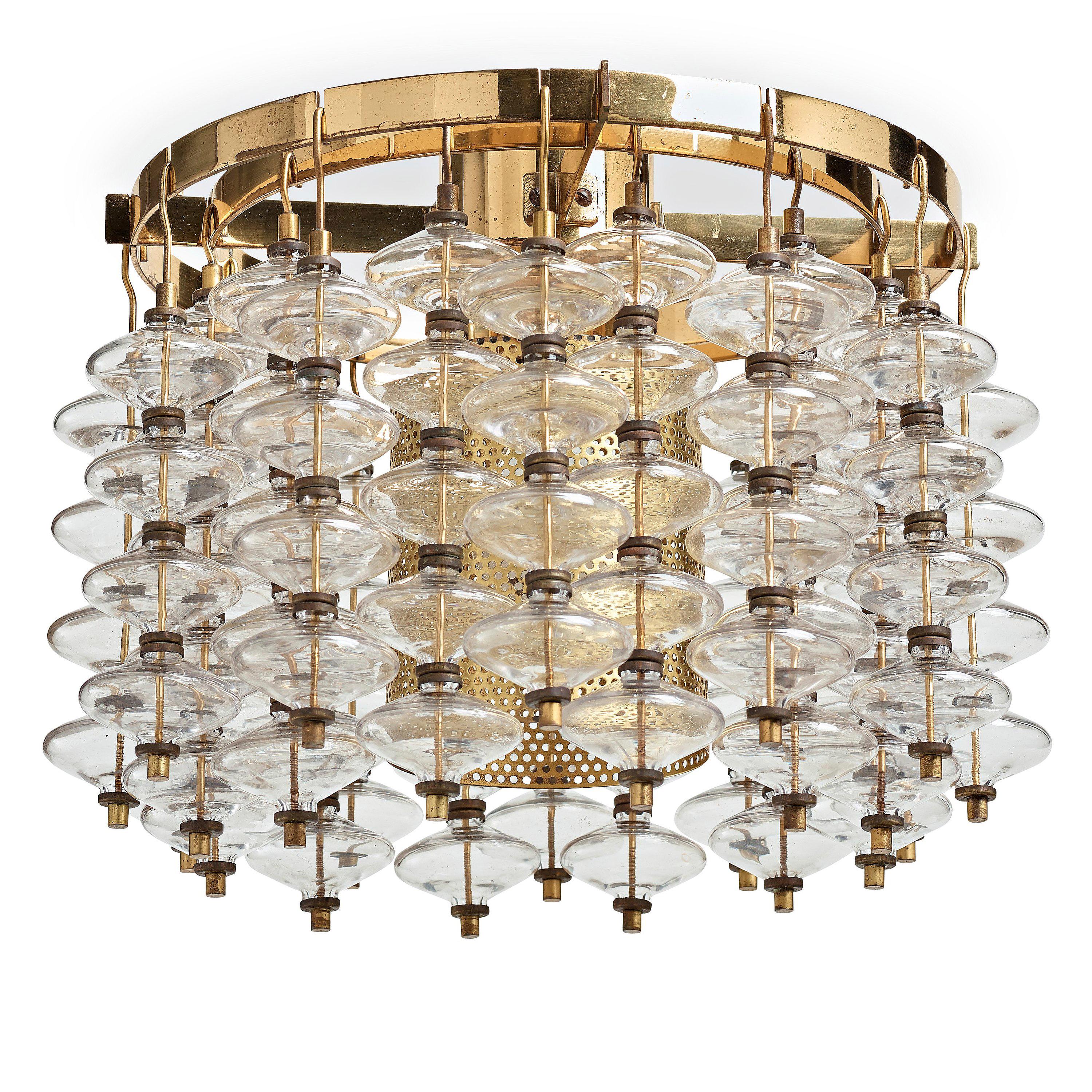 Scandinavian Mid-Century Modern chandelier T-581 by Hans-Agne Jakobsson Markaryd, Sweden. Frame in polished brass. Glass details strung on brass thread. Wire suspension. 
Stunning glass and brass circular chandelier made about 1966. Clear smooth