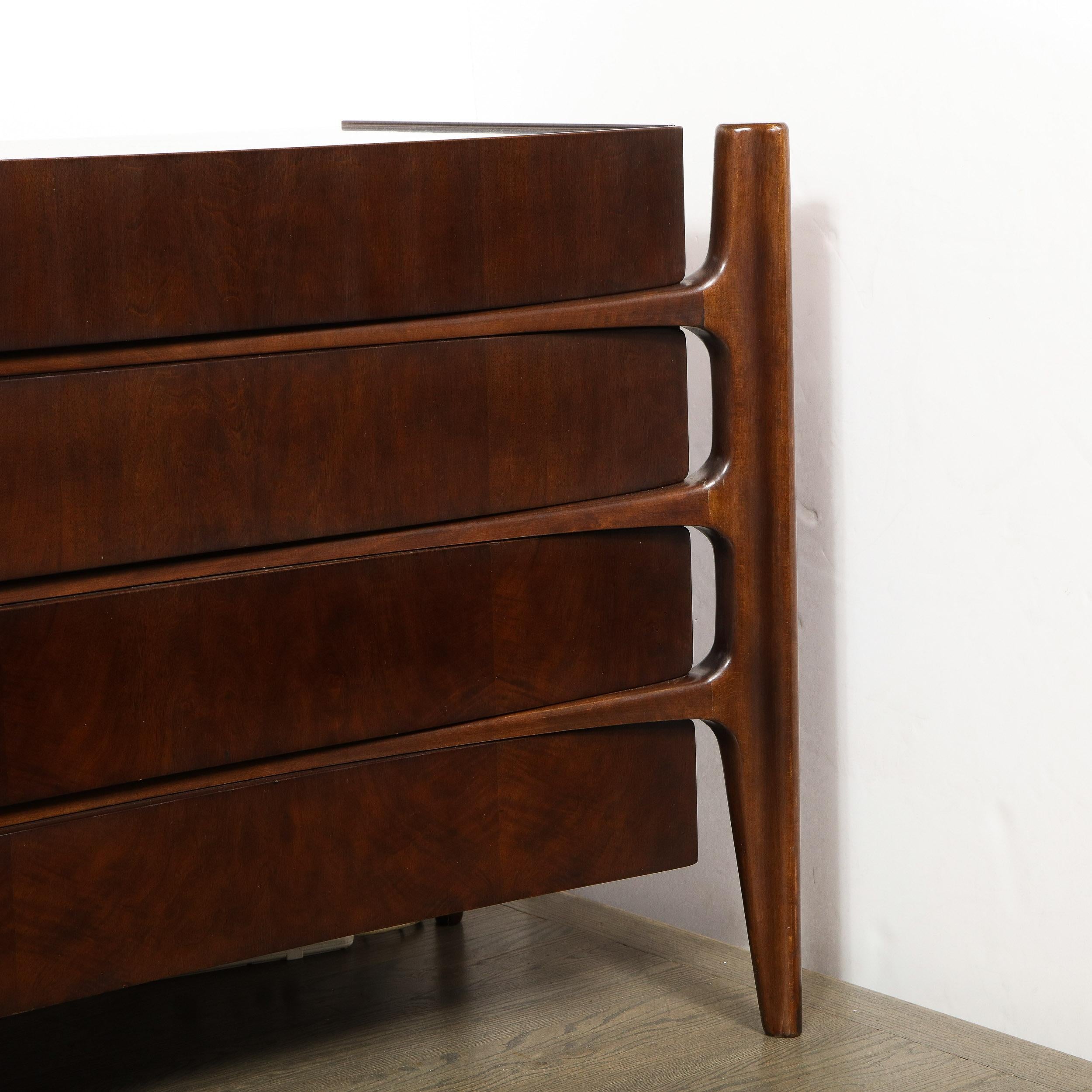 The celebrated Mid-Century Modern Swedish designer William Hinn realized this exceptional and rare eight-drawer walnut dresser, circa 1950. It features four splines, detached from the body of the cabinet, that descend into tapered legs. The splines