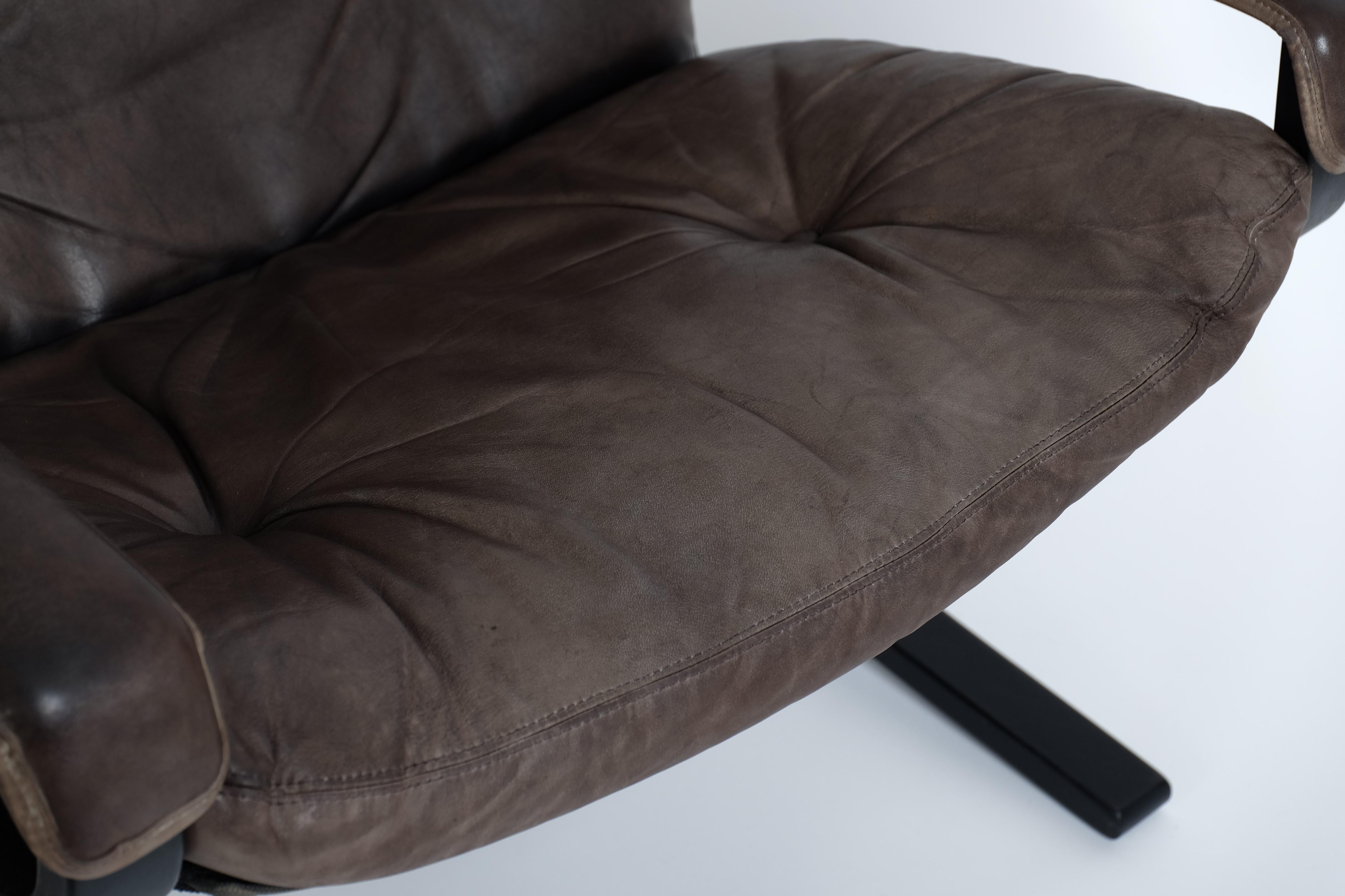 Poltrona Siesta con schienale alto e braccioli in pelle nera e struttura in legno curvato nero. Progettata dall'icona del design norvegese Ingmar Relling alla fine degli anni '60 e prodotta da Westnofa in Norvegia. 

I cuscini dei sedili e il