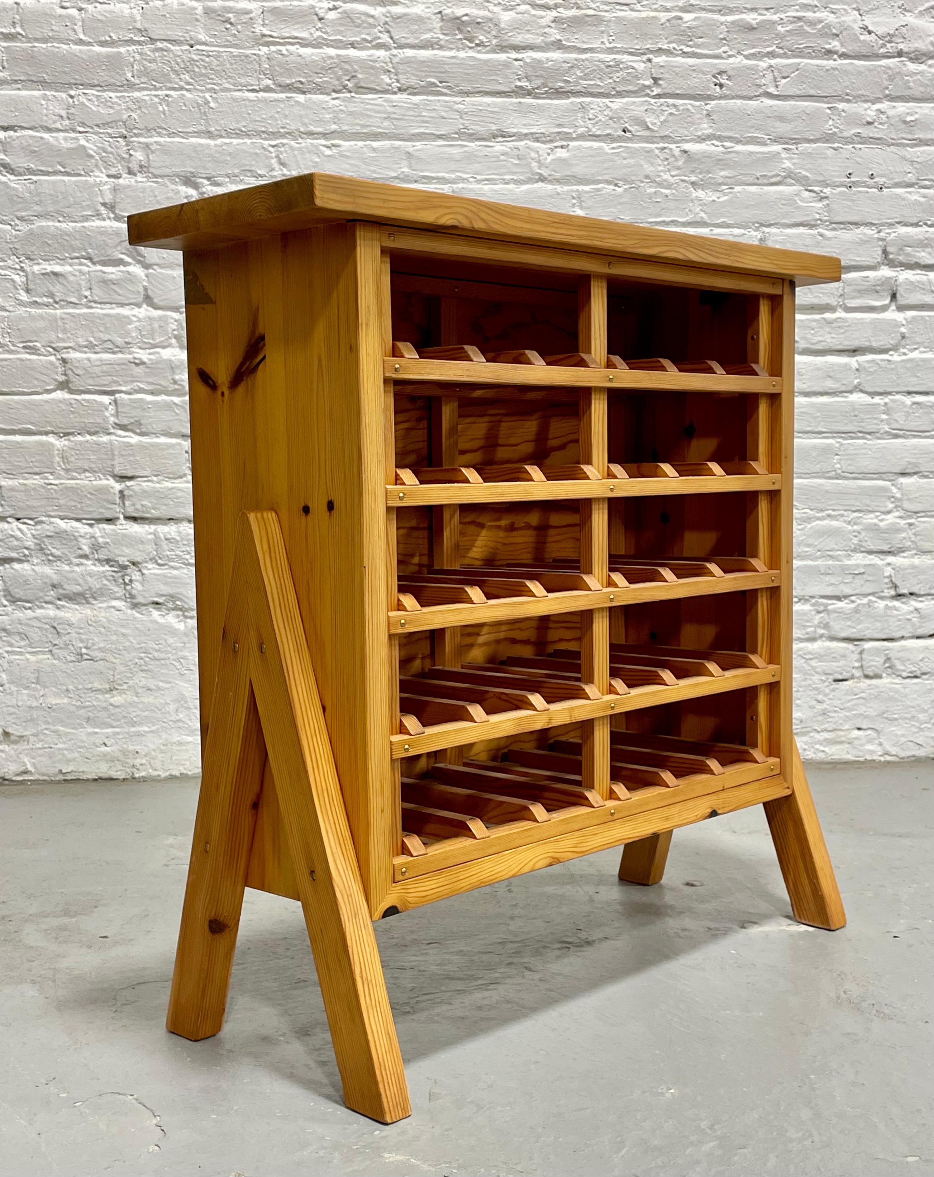 Scandinavian Mid Century Modern Pine Wine rack featuring a floating leg design, c. 1970’s. Made from solid pine and holds 30 bottles. Lovely wood knots adorn the piece along the top and sides. 

Dimensions: 29”W x 12.25”D x 30”H 