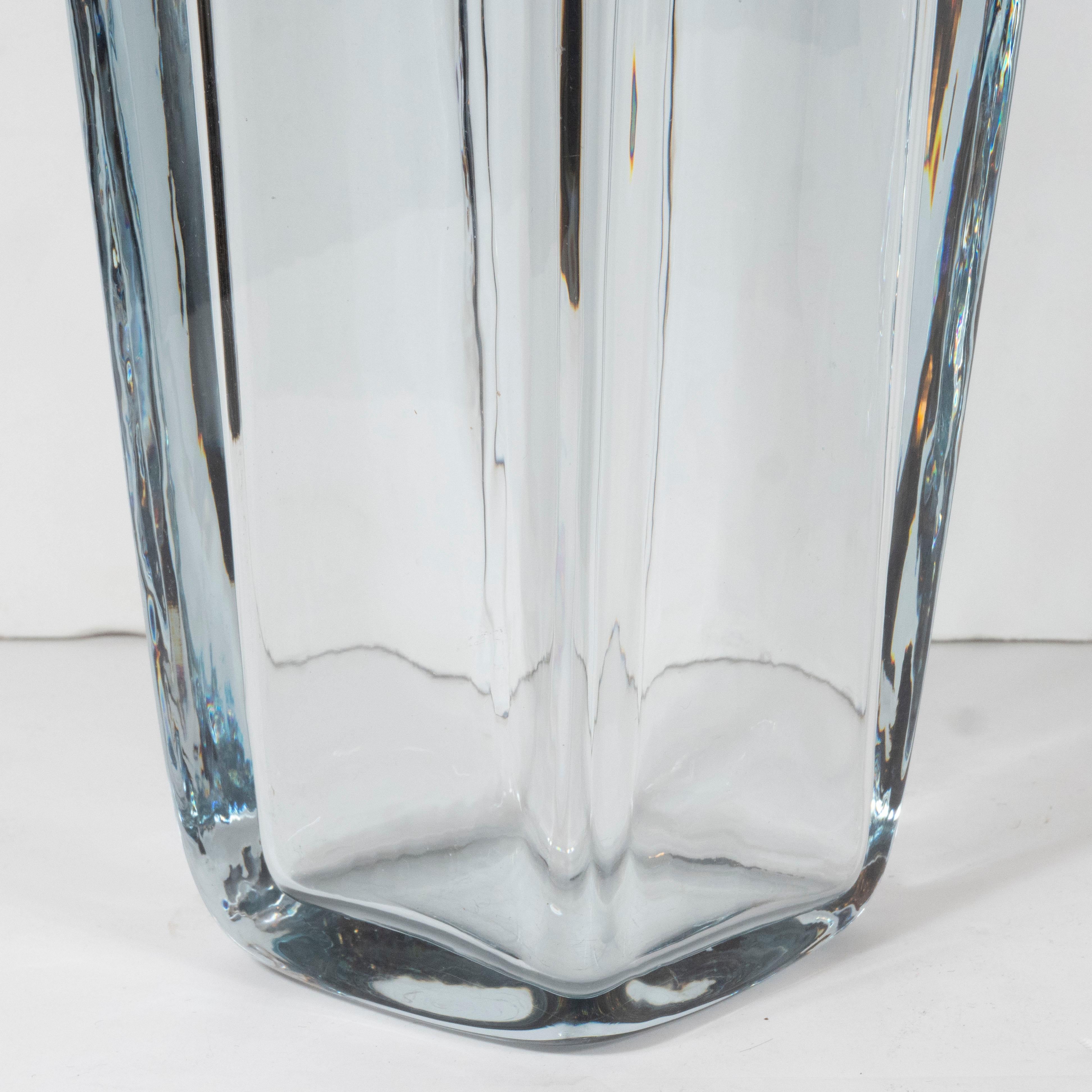 This elegant Mid-Century Modern vase was realized in Sweden circa 1960. It features a volumetric rectangular body with curved shoulders in thick translucent pale blue hand blown glass. With its clean lines and beautiful glass quality, this piece