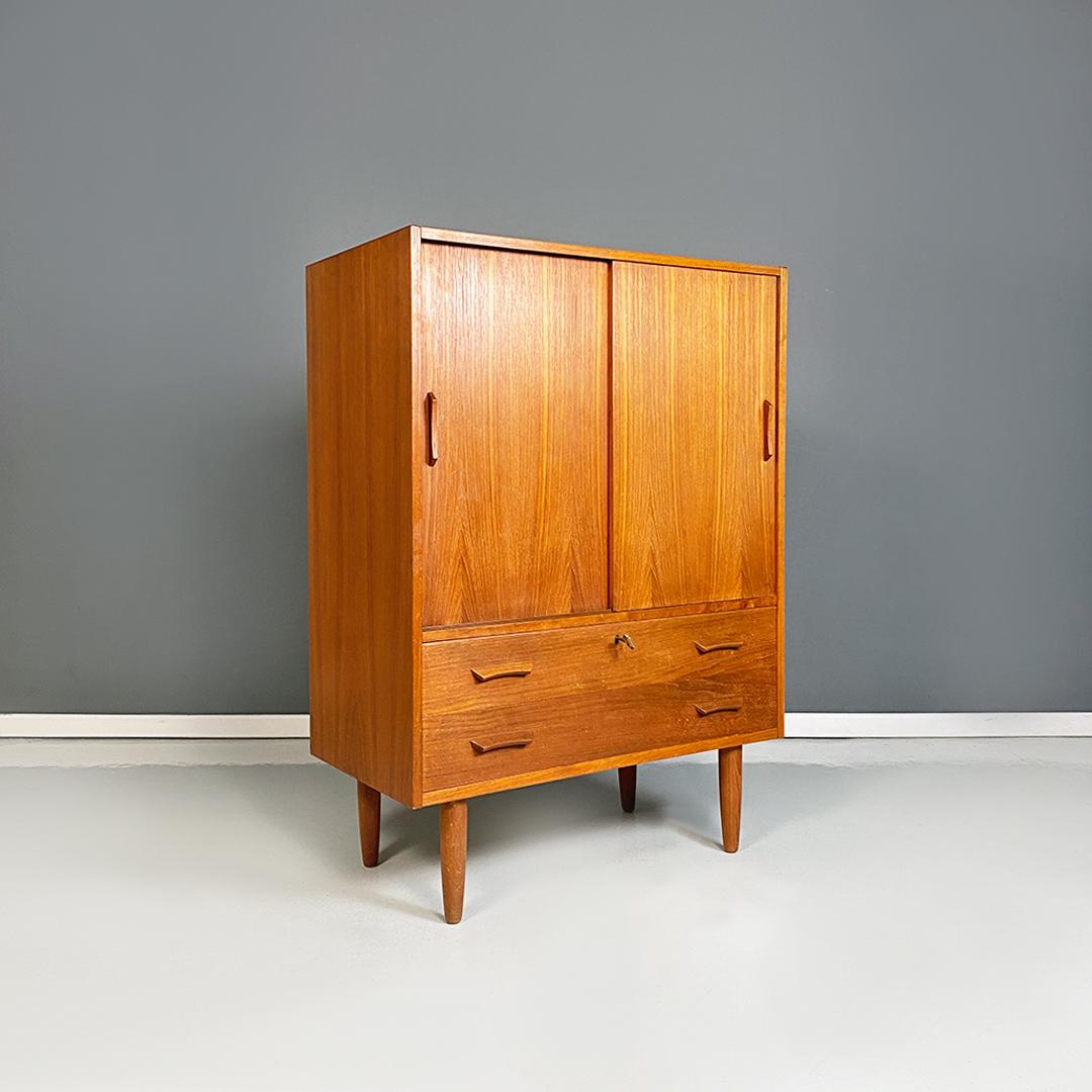 Scandinavian mid century modern teak highboard with sliding doors, 1960s.
Small cabinet or highboard of Scandinavian origin, completely in teak, with sliding doors and central shelves, four drawers placed in the lower part and shaped handles. Round