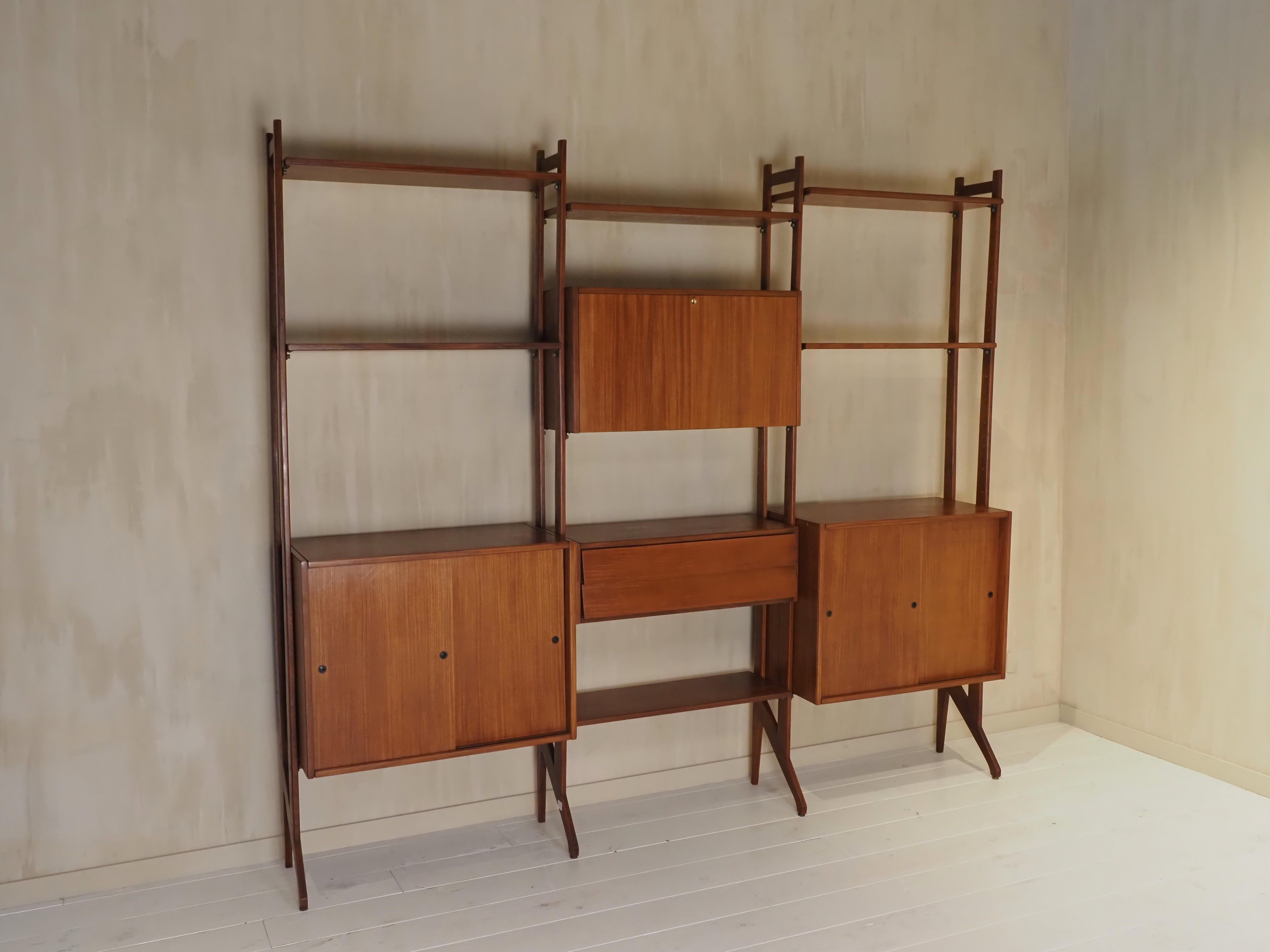 Splendido pensile moderno di metà secolo, realizzato in ricco legno di teak. Questo sistema di scaffalature modulari è caratterizzato da un design scandinavo estremamente minimalista, che unisce funzionalità e stile senza tempo. Può essere