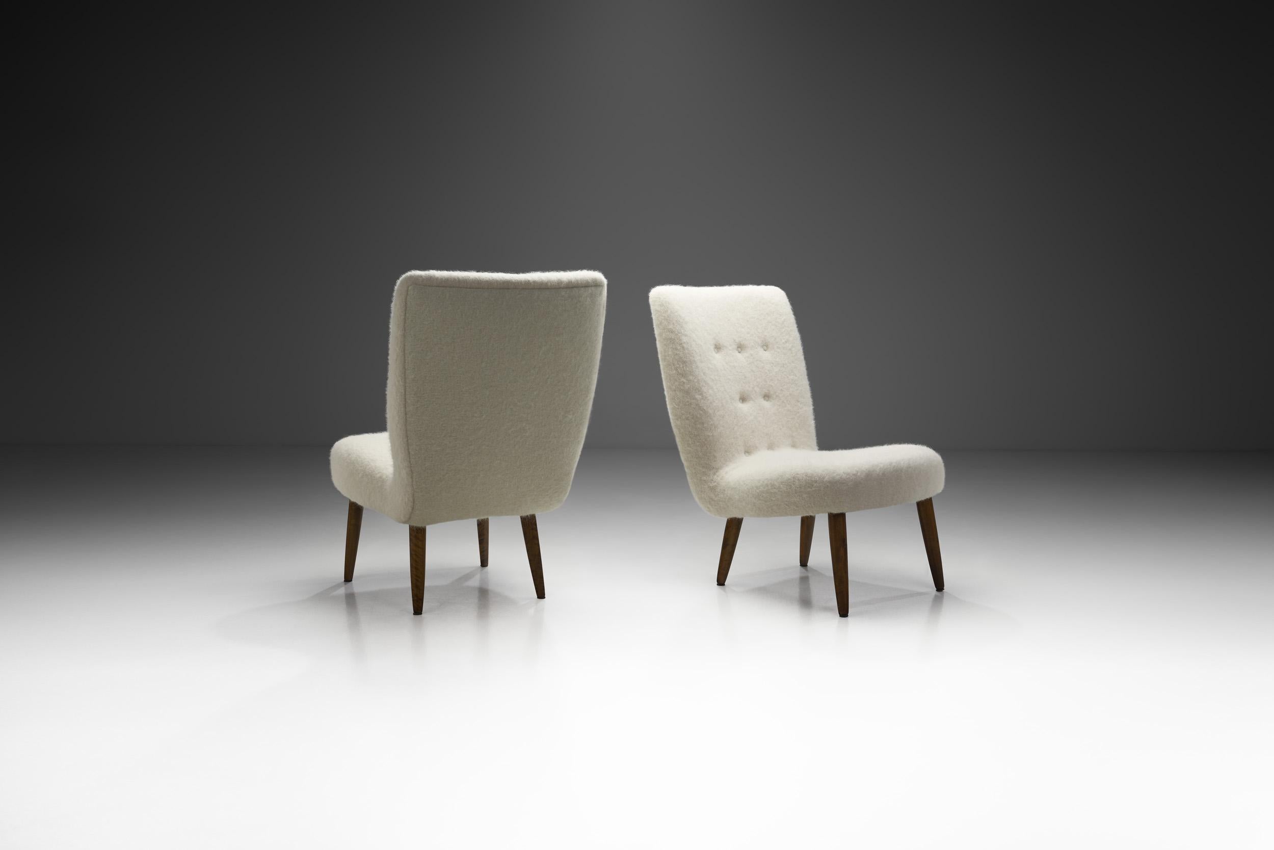 This pair of easy chairs is exemplary of the main ideals of mid-century modernism: the chairs are characterized by clean, simple lines, honest use of materials, and a lack of unnecessary decorative embellishments. Instead, the focus is on