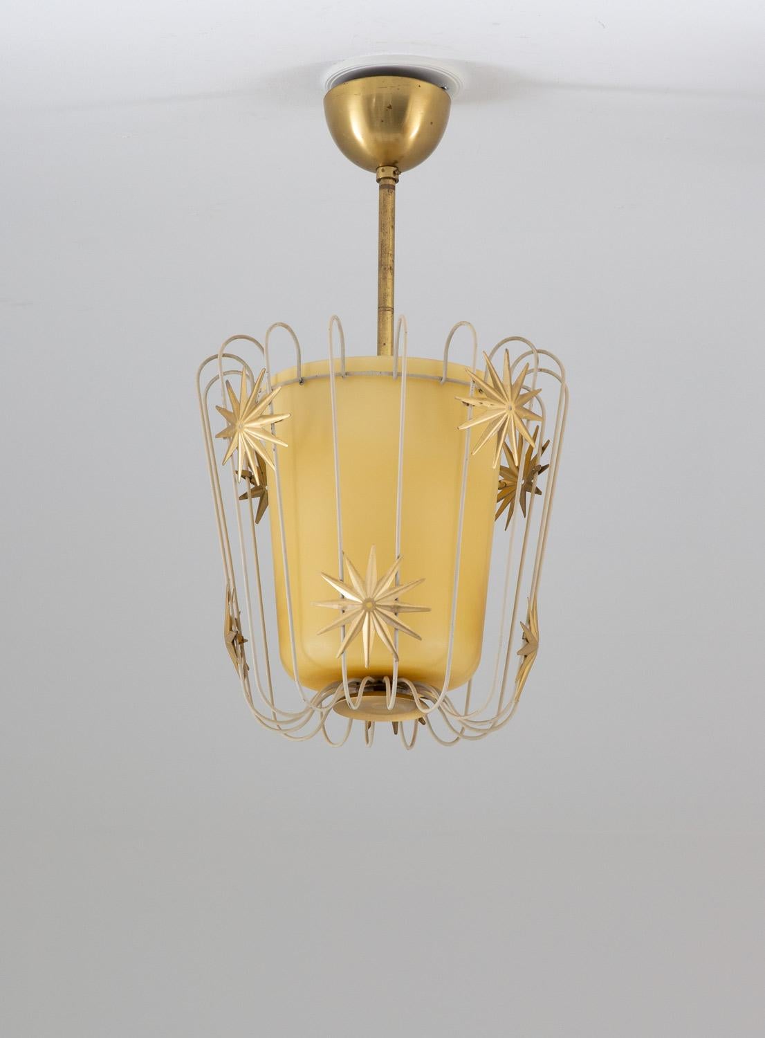Elegant pendant in brass, metal and frosted glass produced in Sweden.
The lamp consist of a glass shade, surrounded by metal strings with star shaped ornaments.

Condition: Good original condition with patina.