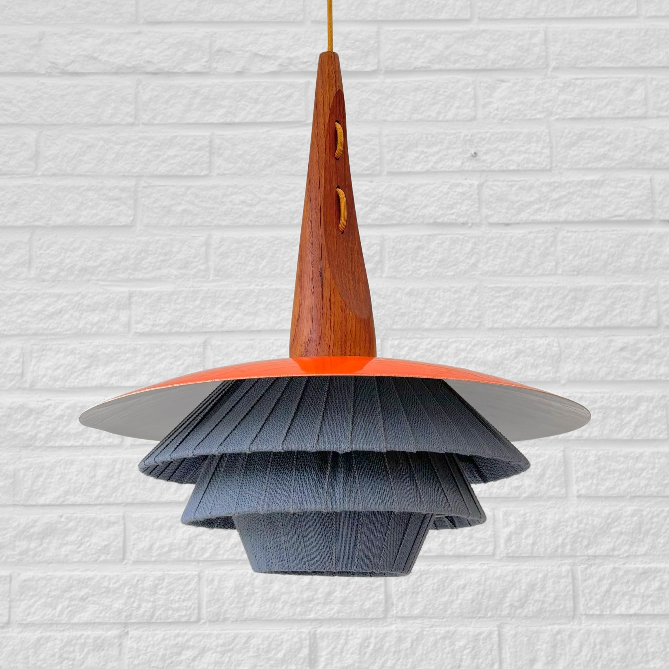 Una lampada a sospensione scandinava di metà secolo, prodotta da un produttore svedese non identificato negli anni Cinquanta. Questo pezzo insolito mostra la raffinata lavorazione artigianale tipica dell'epoca, con un corpo affusolato in teak