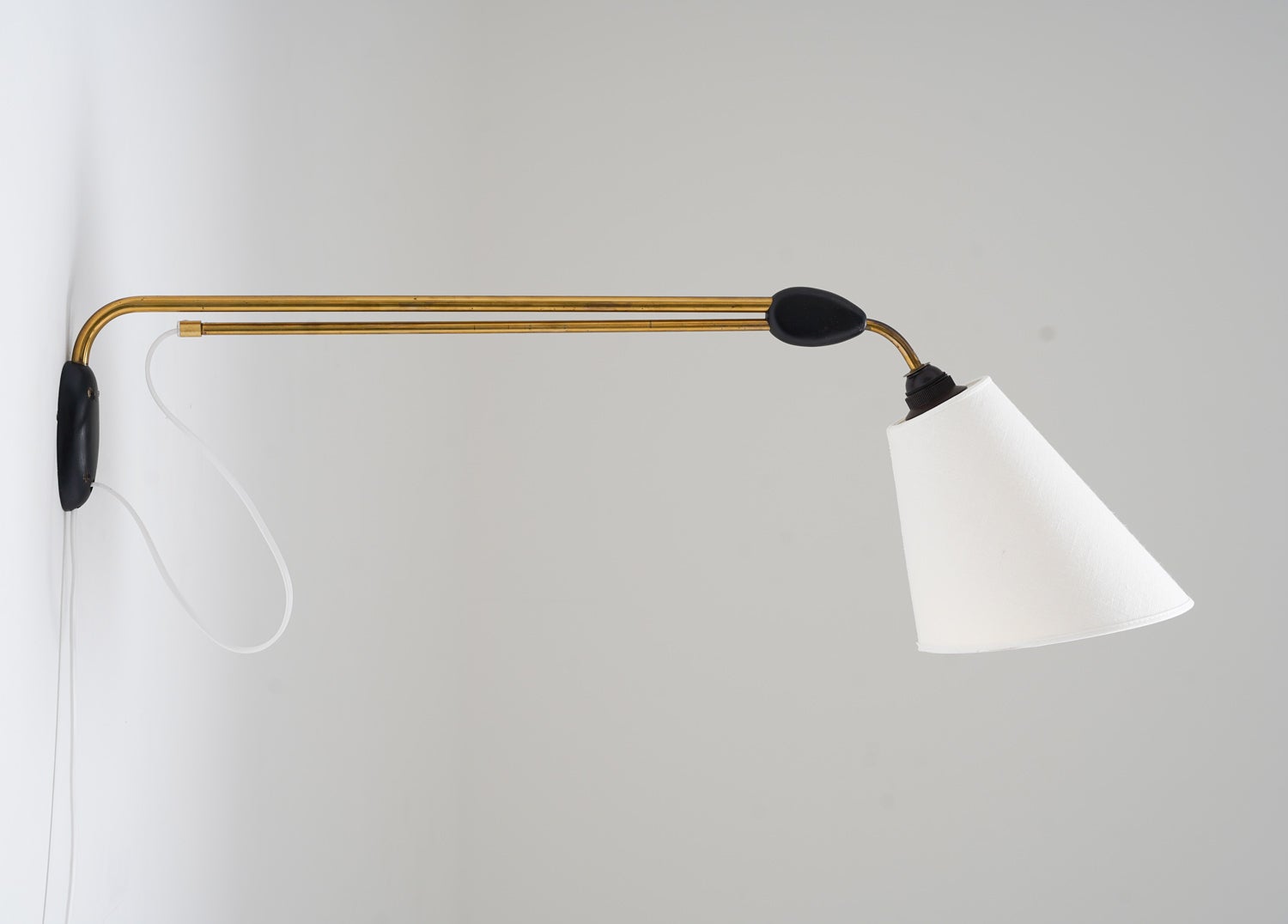 Schöne Wandlampe, hergestellt in Schweden um 1950 von Pagos.
Die Lampe besteht aus zwei Messingstäben, die durch ein Holzstück verbunden sind, wobei sich der untere Stab verschieben lässt, um die Länge zu verlängern. Die Länge kann zwischen 88 und