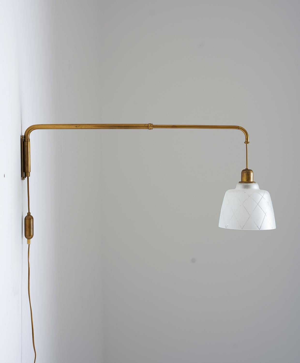 Beautiful wall lamp, manufactured in Sweden circa 1940.
This lamp consists of an extendable brass rod, holding the beautiful frosted glass shade. A counterweight keeps the shade in place and the length of the rod can be adjusted between 50 to