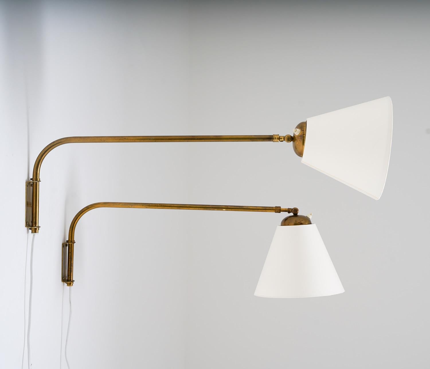 These beautiful wall lamps were manufactured in Sweden in the 1940s by EAE. They consist of an extendable brass rod, which holds the adjustable shade. The length of the rod can be adjusted between 60 and 100cm (23