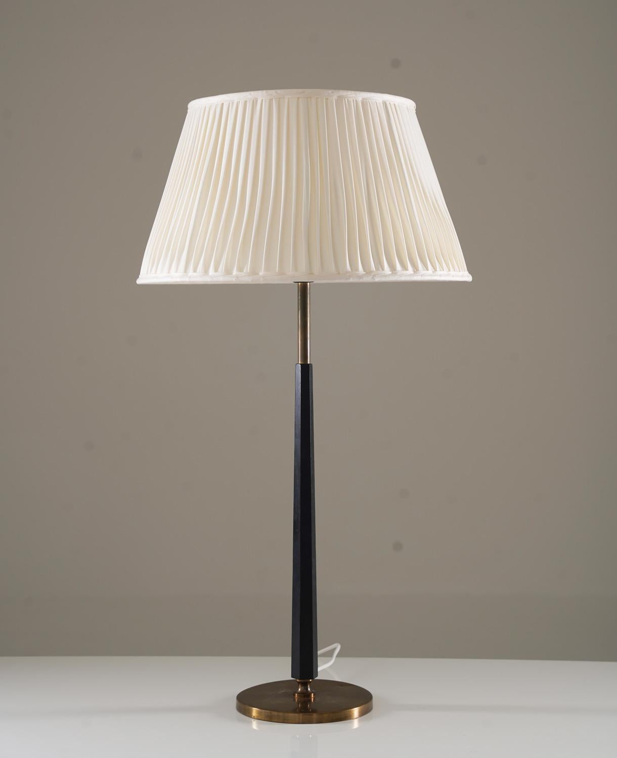 Cette grande lampe de table, fabriquée par ASEA dans les années 1950, incarne le design scandinave du milieu du siècle par son élégance intemporelle. La lampe présente une base conique noire associée à des accents en laiton, offrant un contraste