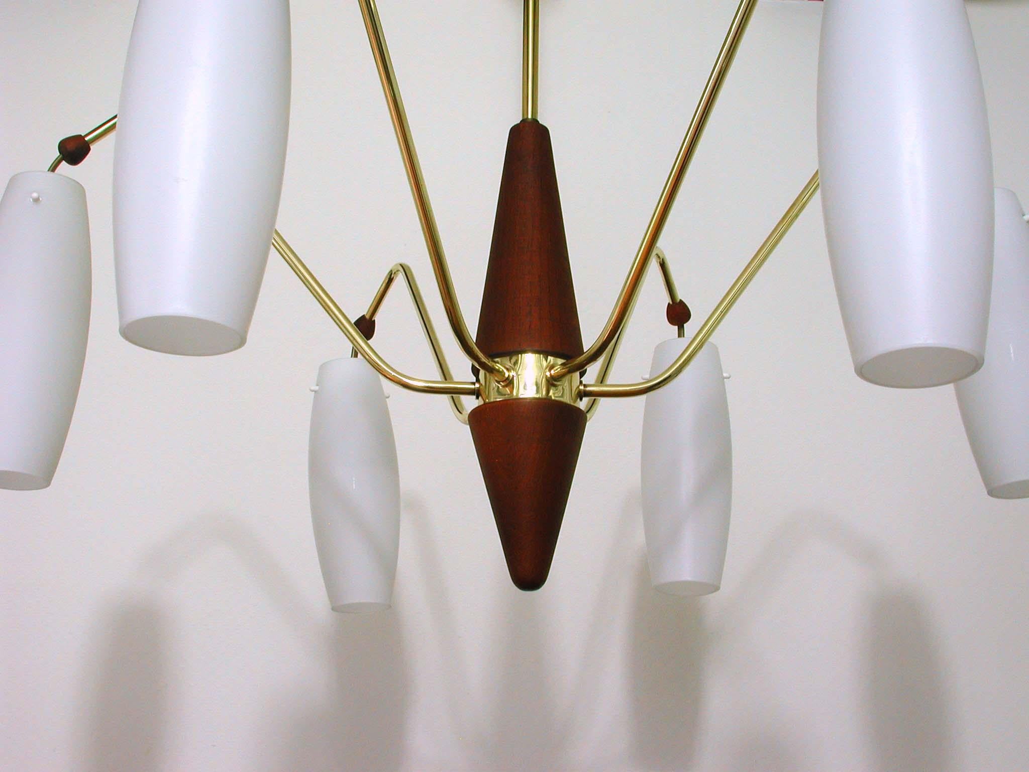 This six-light chandelier was manufactured in Sweden in the late 1950s to early 1960s. It is made of brass and teak and has got six opal glass lampshades. 

Condition is very good and the lamp is in full working order, cleaned and all brass pieces