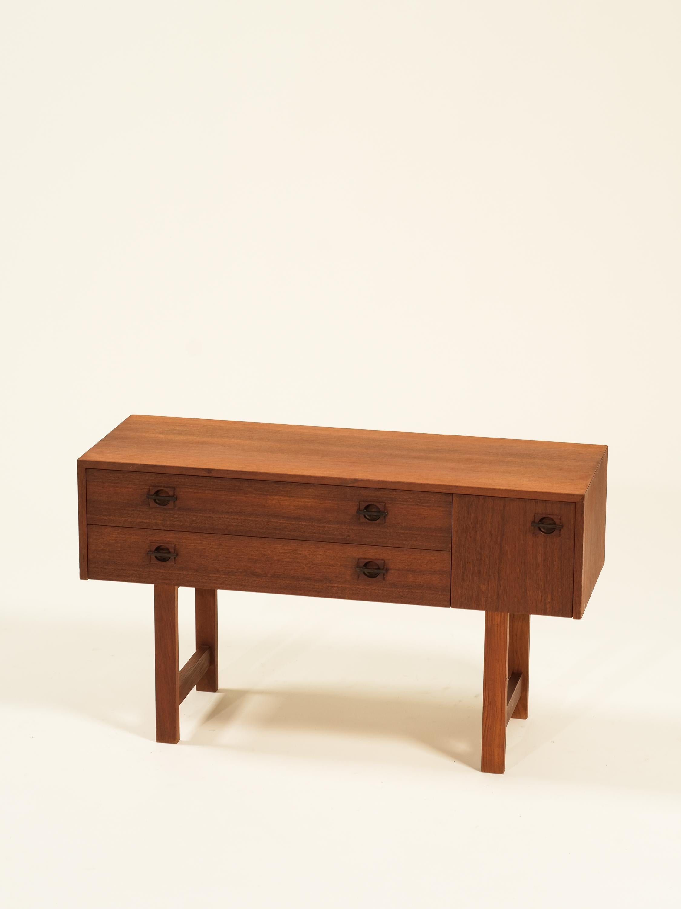 Consola escandinava de tres cajones de mediados de siglo en madera de teca. Su diseño elegante y su amplio espacio de almacenamiento lo convierten en el complemento perfecto para cualquier salón.