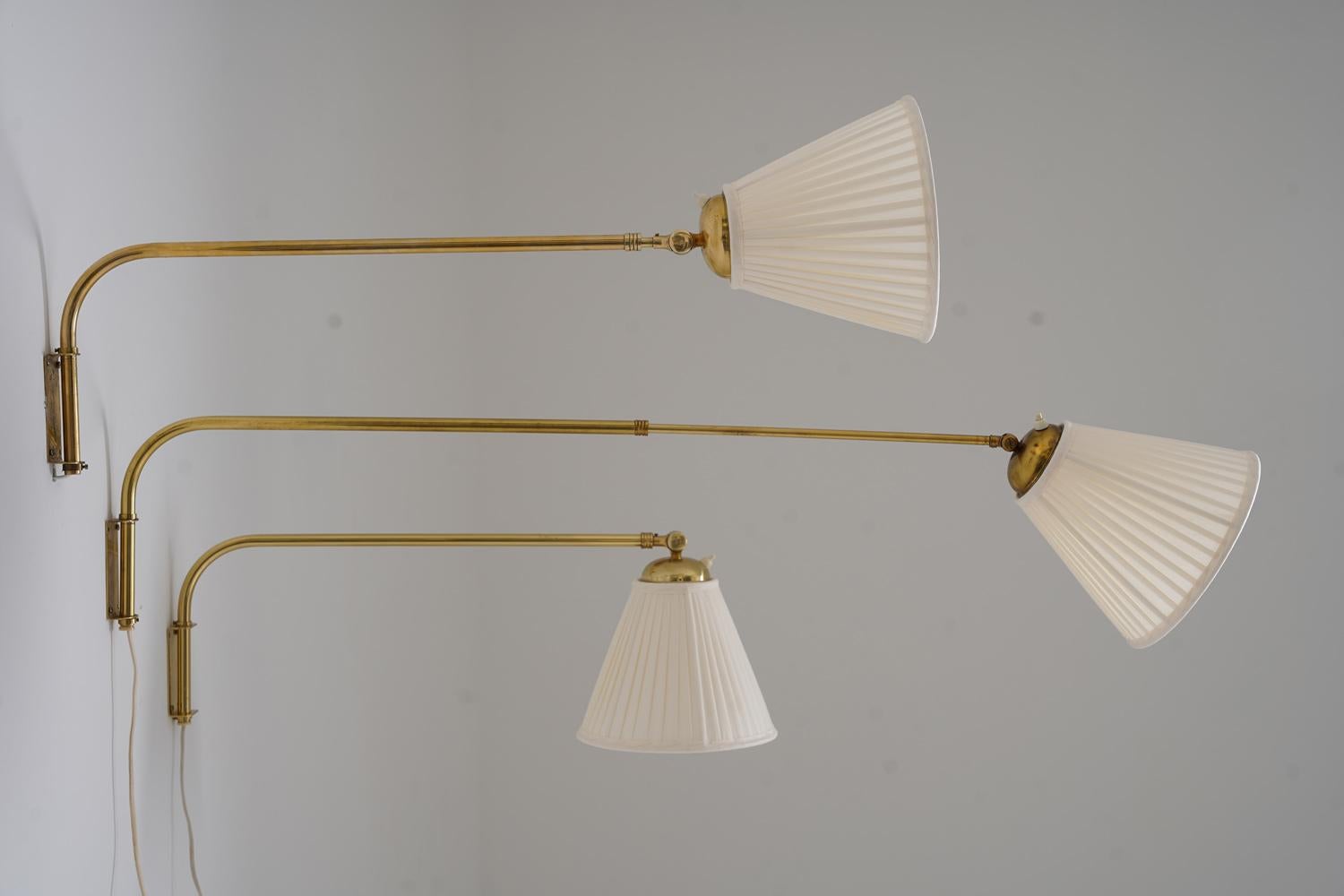 Apliques suecos, fabricados en la década de 1950 por Eskilstuna Armatur Elektriska. Cada lámpara dispone de un brazo extensible de latón, ajustable entre 60 y 100 cm, que ofrece un posicionamiento versátil para una iluminación específica. La
