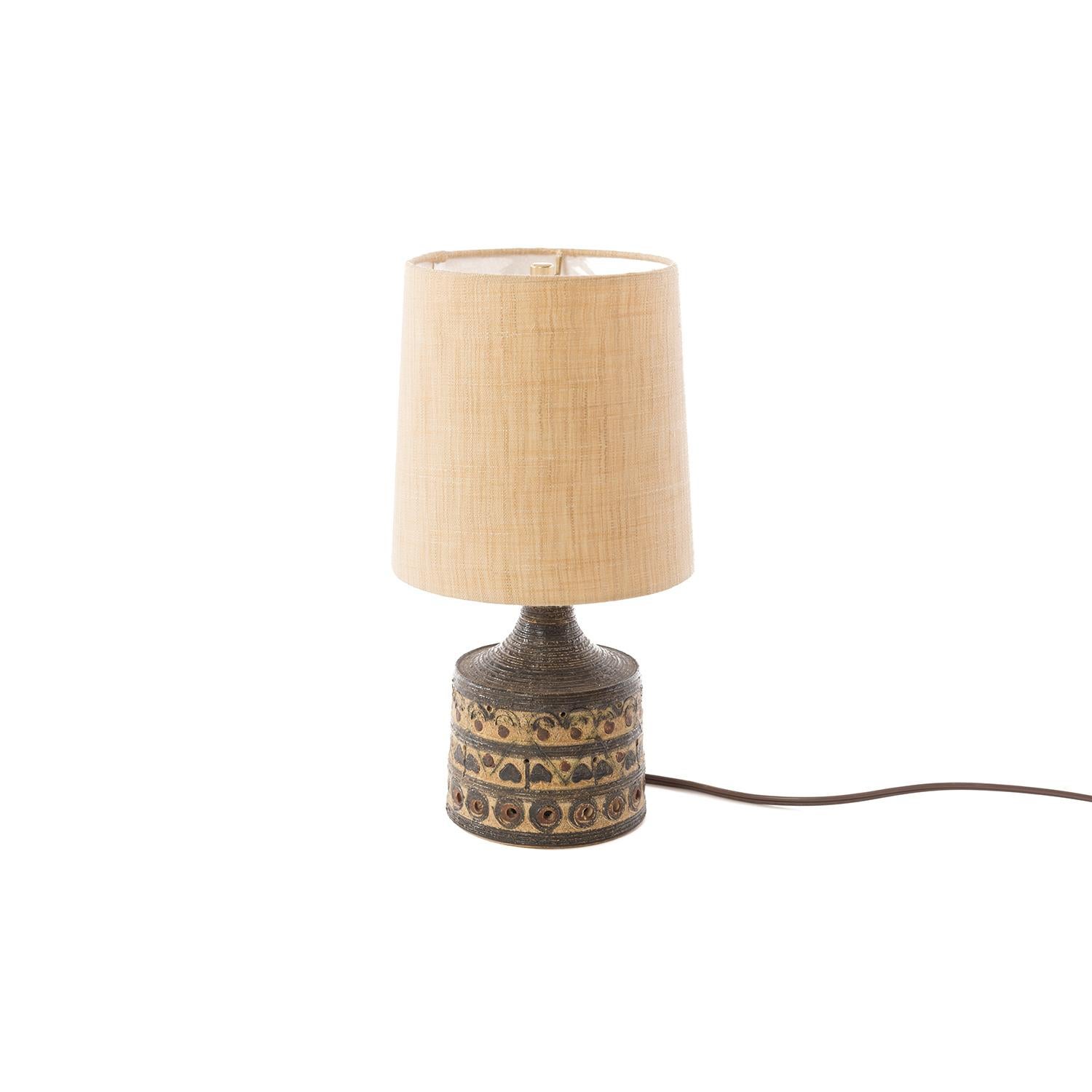 This mid-sized table lamp has it all, bullseye reliefs, swirls and upside down hearts. Sand and deep brown tones in the glaze. All topped off with a new natural fiber flax shade. From Denmark. Lamp has been updated with North American wiring or plug