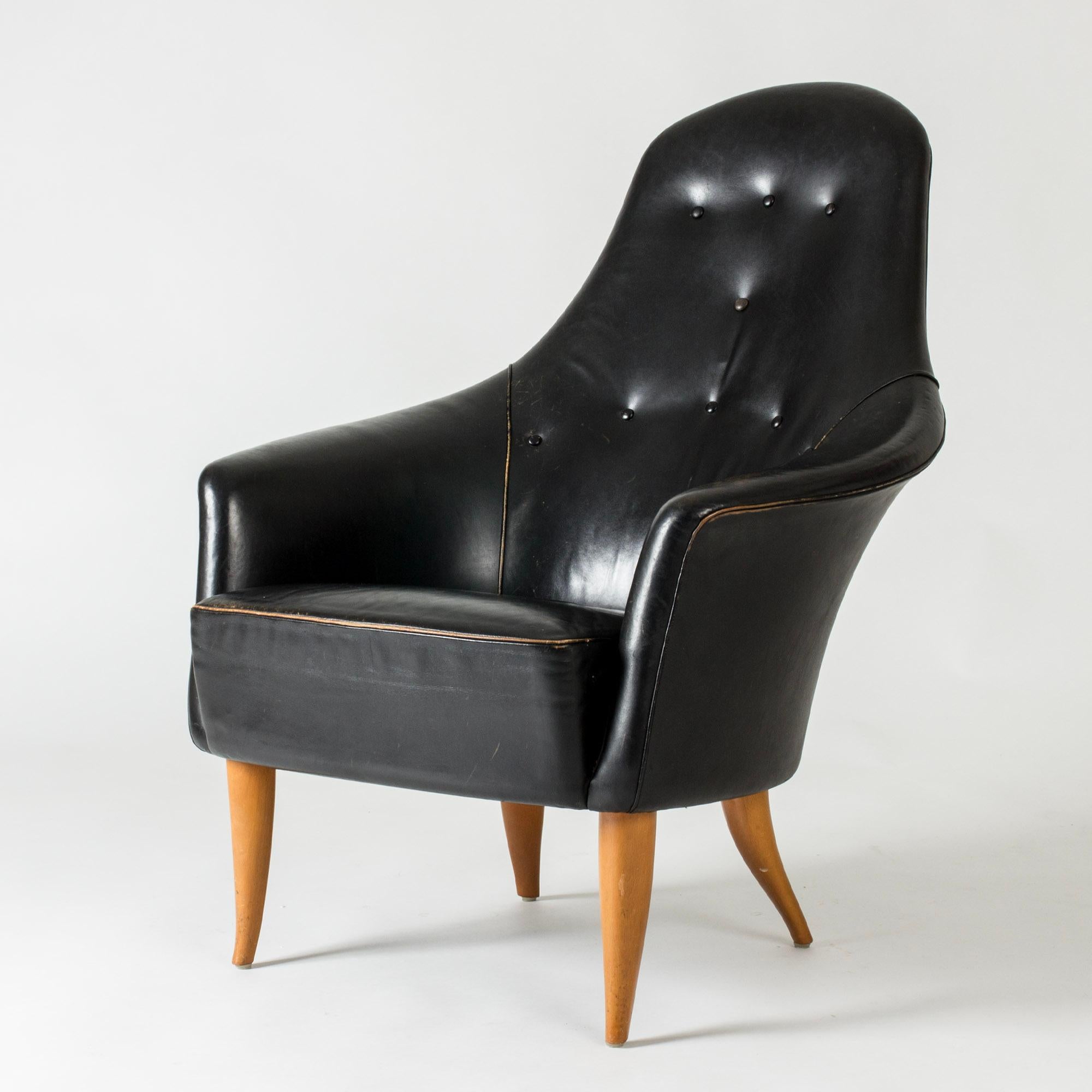 “Big Adam” (“Stora Adam”) lounge chair by Kerstin Hörlin-Holmquist, from the “Paradis” series. Upholstered with black leather in nice condition, some wear on the piping.