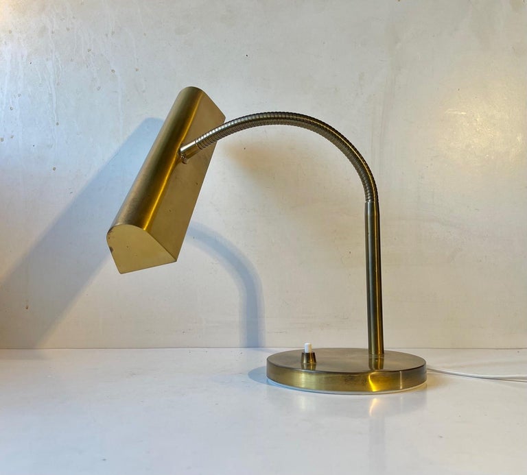 This midcentury danish bankers table light features two lightsources. Its made entirely out of brass and has a multi-adjustable gooseneck that allows you to direct the light in any direction. It was manufactured and designed in-house by E. S. Horn