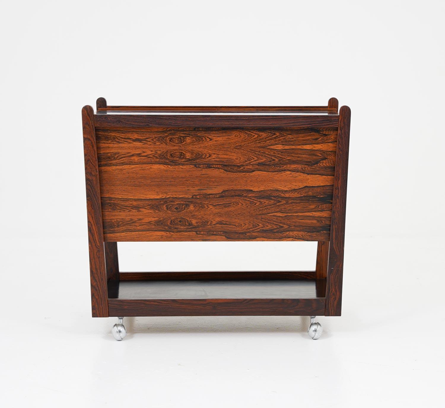 Bar cart designed by Rolf Hesland for Bagn Møbelindustri, Norway.
The bar cart has a sliding Formica top, which hides a space to store liquor and glasses. The rosewood shows an intensive grain. 

Condition: Very good original condition.
