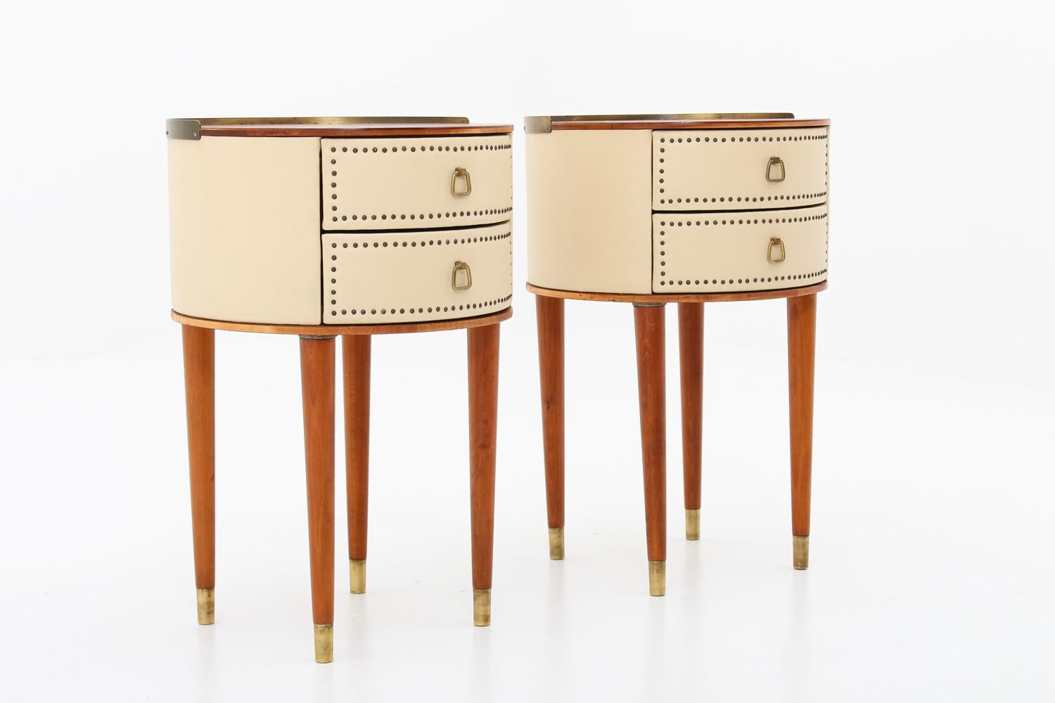 Designed by Halvdan Pettersson for Tibro Möbelfabrik, circa 1940.
These round bedside tables are covered in cream white faux leather with brass details. The tabletop is made of mahogany and the legs of stained beech.
Condition: Very good restored