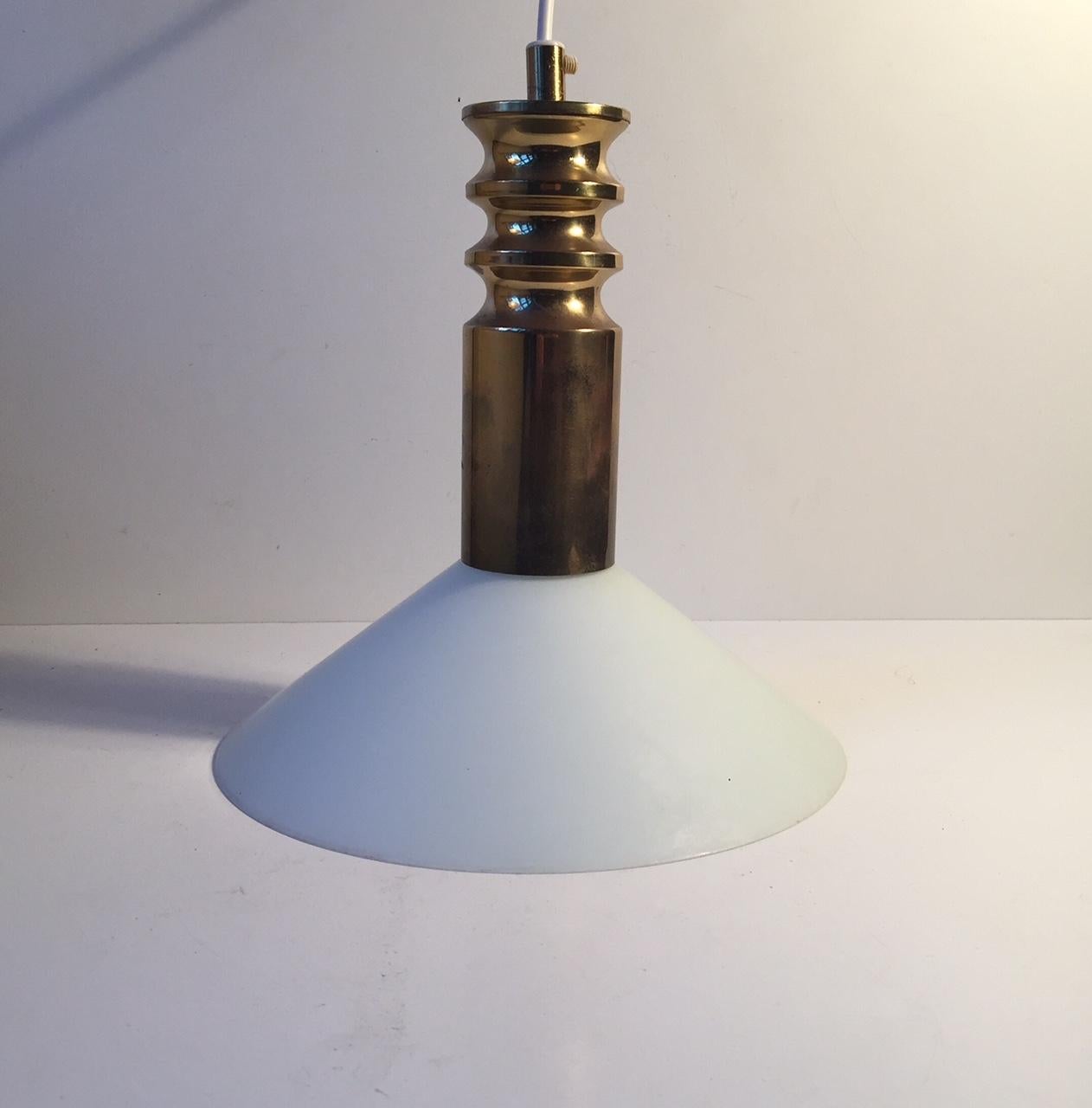 This Frimann hanging Light is fashioned out of brass and opaline glass. It was manufactured and designed by Frimann in Denmark during the 1970s. The style is reminiscent of Hans-Agne Jakobsson and Lisa Johansson-Papé.