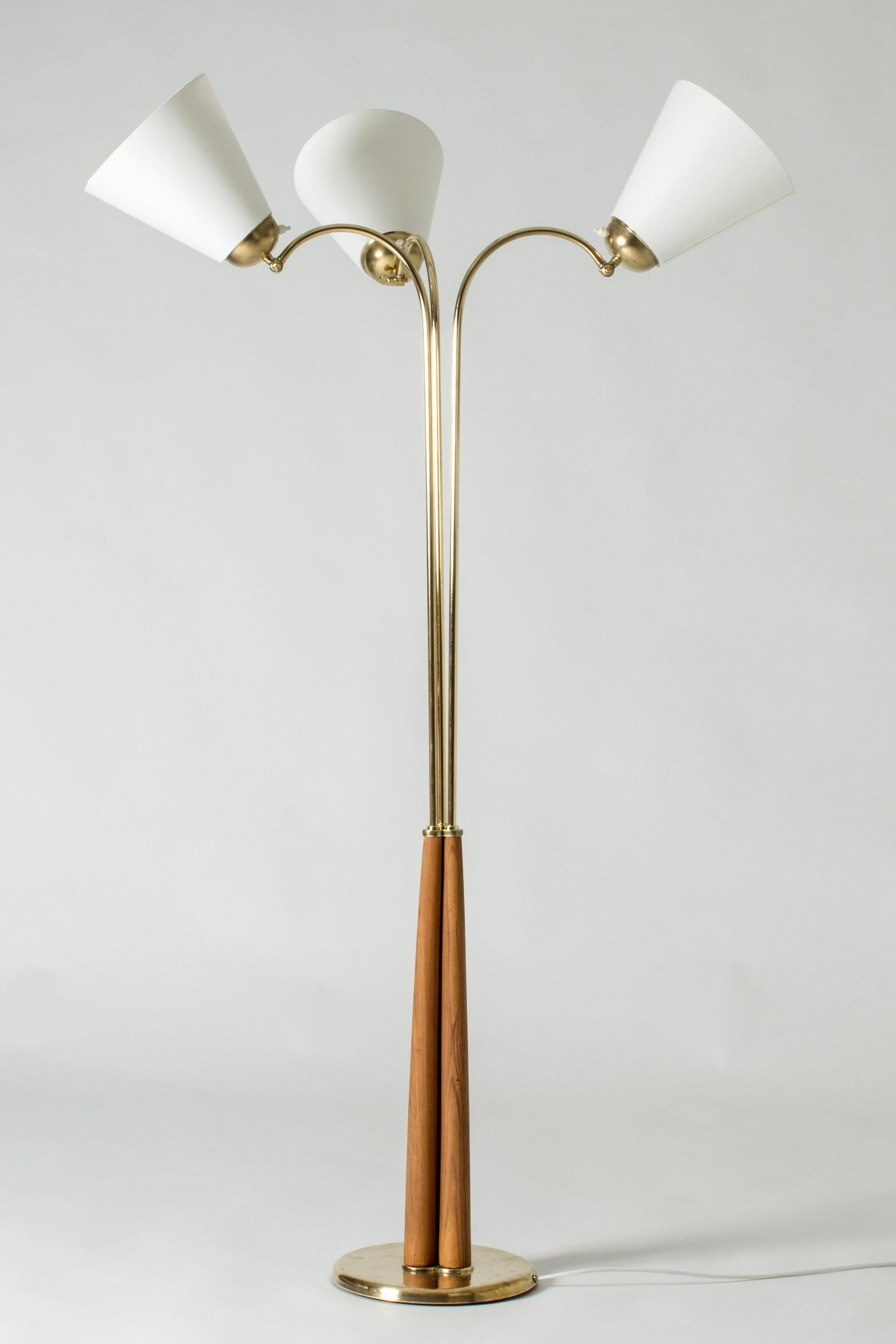 Elegant Swedish Modern floor lamp, made from brass with three lamp shades. Tapering wooden base with nice woodgrain. The direction of the lamp shades can be adjusted.