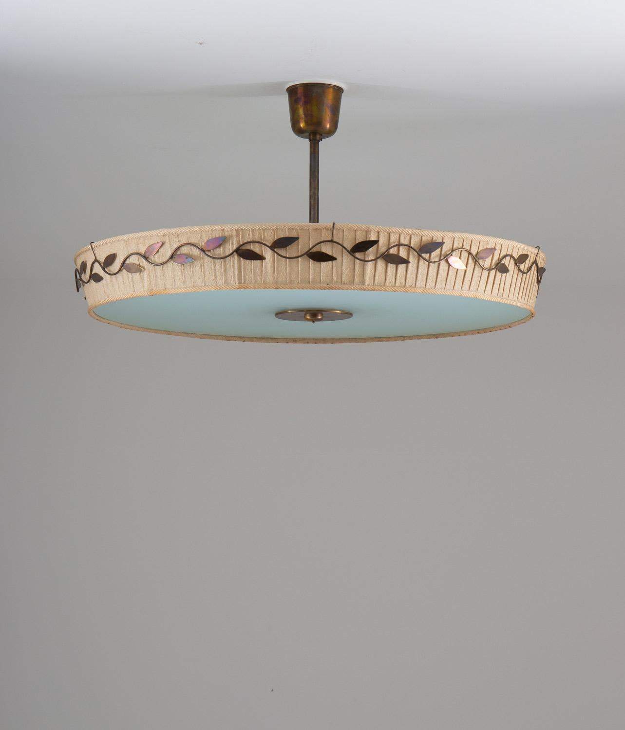 Large ceiling lamp in brass, glass and fabric by Hans Bergström for Ateljé Lyktan, 1940s.
The lamp consists of a fabric shade with brass ornaments, resting on a large (88cm) frosted glass shade. 

Condition: Good/fair original condition. Dark