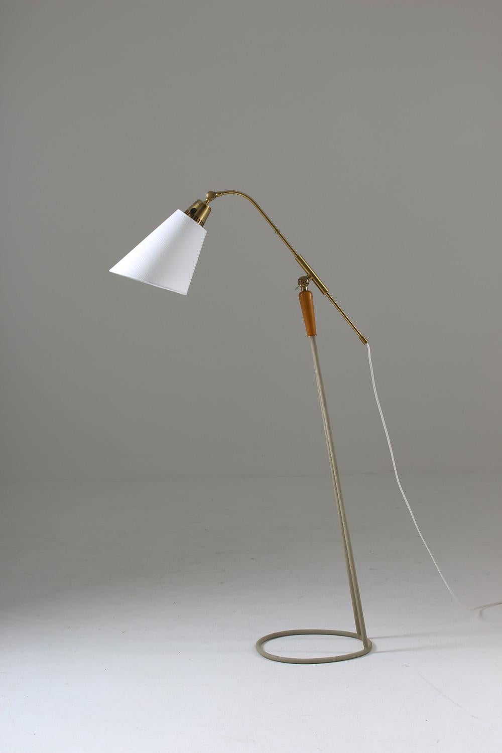 Lovely floor lamp in brass, metal and wood model 7069 by Swedish manufacturer Falkenbergs. 
The lamp is adjustable in both height and angle, making it a perfect reading lamp beside the sofa. All parts are original except for the new shade and