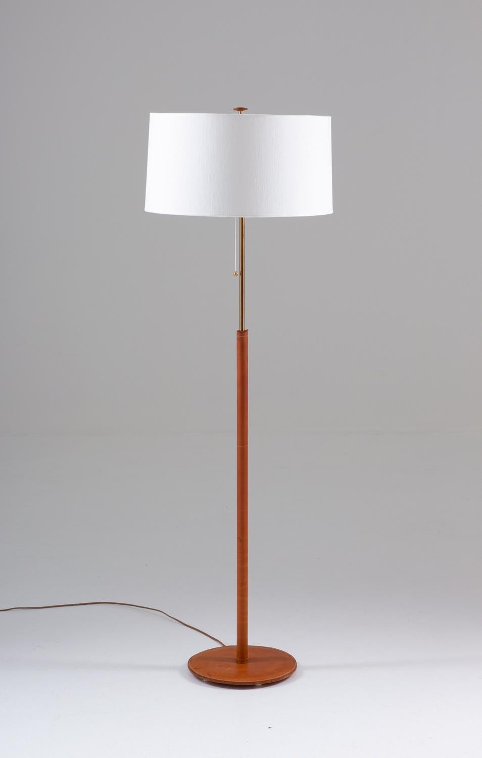 Scandinavian midcentury floor lamp in brass and leather by Bergboms, Sweden, 1960s.
This rare lamp is made of solid brass, covered in cognac-coloured leather. It comes with its original shade, which has been restored with new white linen