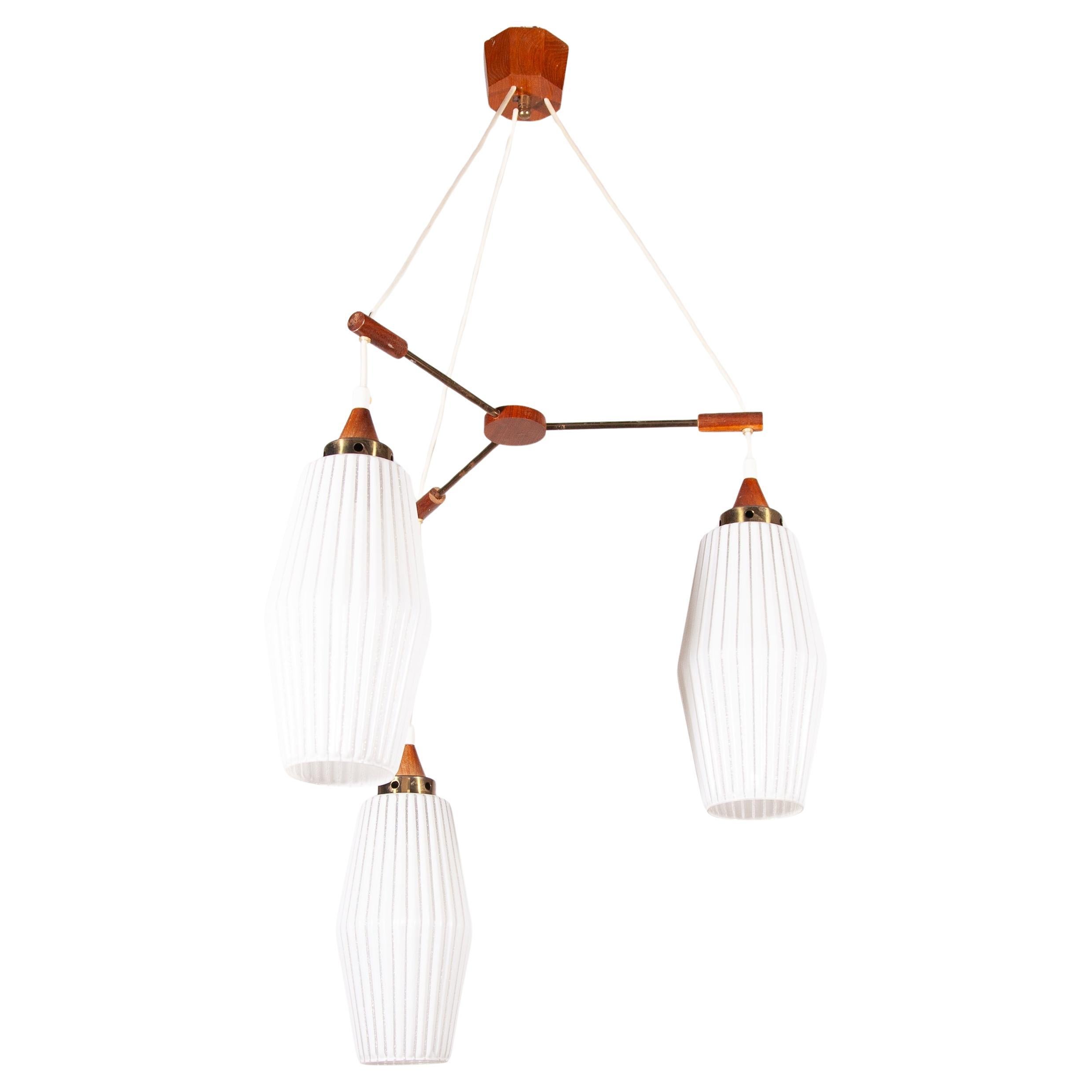 A beautiful set of three cascading opaline shades connected to a teak wooden designed structure a typical fifties Scandinavian design to create a warm light accent in your home.