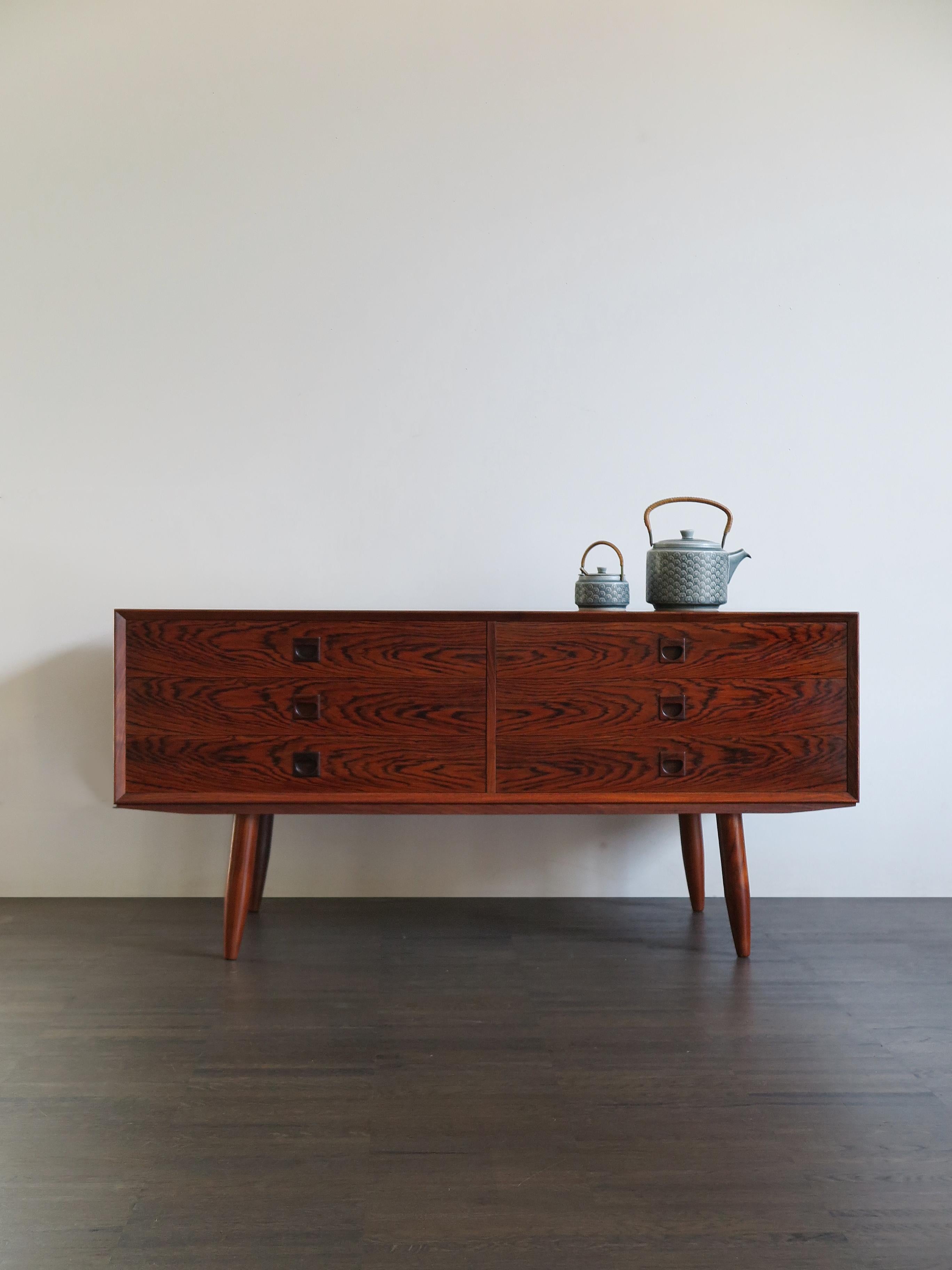 Scandinavian dark wood chest produced in Denmark from 1950s.

Please note that the item is original of the period and this shows normal signs of age and use.