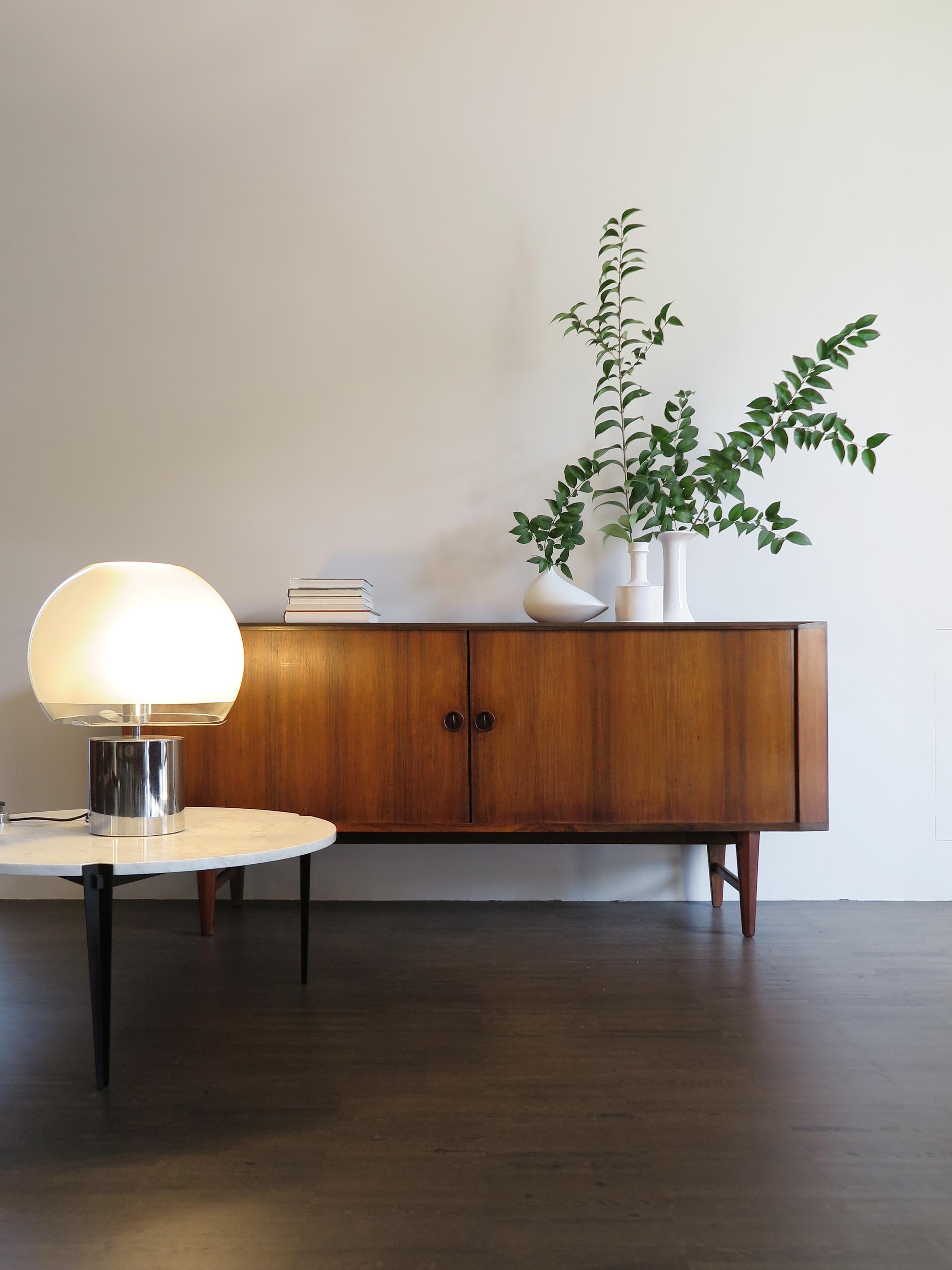 Midcentury modern design scandinavian dark wood sideboard with two sliding doors and internal drawers, manufactured in Denmark from 1950s.
Please note that the sideboard is original of the period and this shows normal signs of age and use.