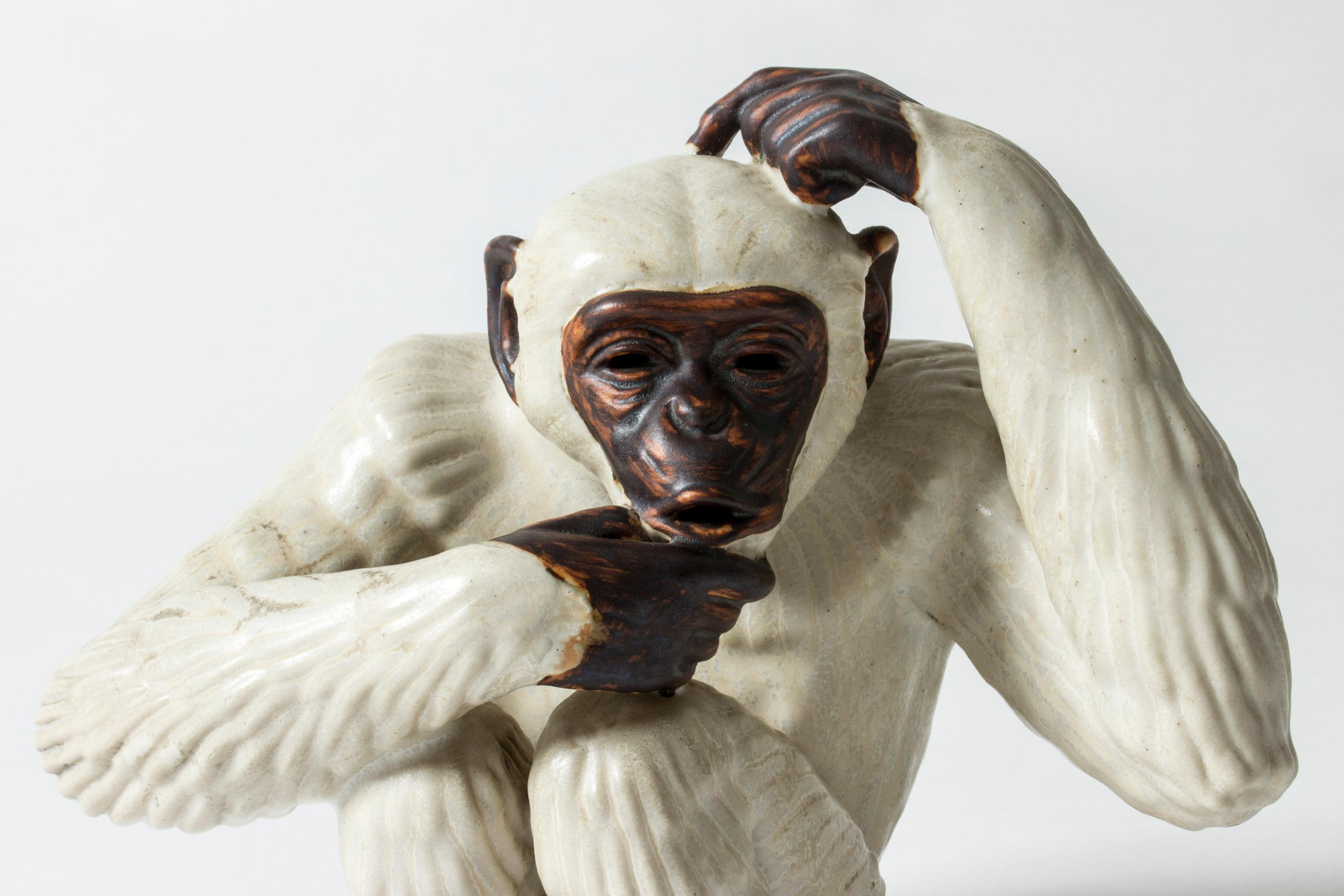 Adorable stoneware monkey figurine by Gunnar Nylund, glazed white and dark brown. Beautifully sculpted, with a spirited expression. Gunnar Nylund’s animal figurines are among his most loved creations, combining naturalistic and modernist elements
