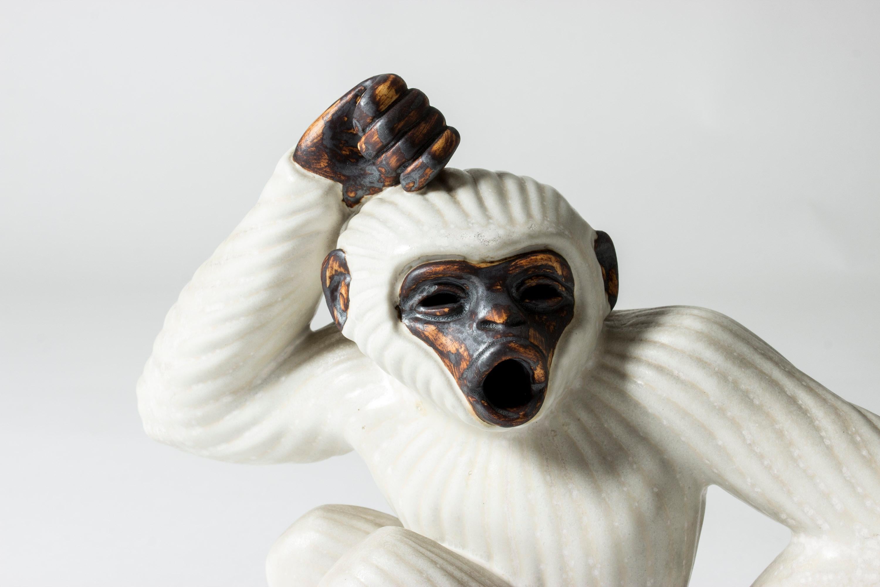 Adorable stoneware monkey figurine by Gunnar Nylund, glazed white and dark brown. Beautifully sculpted, with a spirited expression. Gunnar Nylund’s animal figurines are among his most loved creations, combining naturalistic and modernist elements