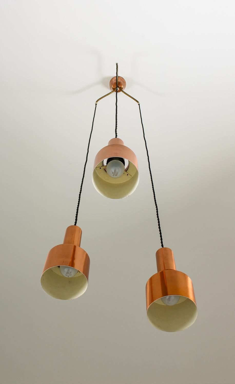Meravigliosi ciondoli dei primi tempi, modello T292, in rame massiccio di Hans-Agne Jakobsson, disegnati nel 1958. 
La lampada è composta da tre pendenti collegati da un divisorio in rame e ottone. La luce si diffonde magnificamente dal paralume in