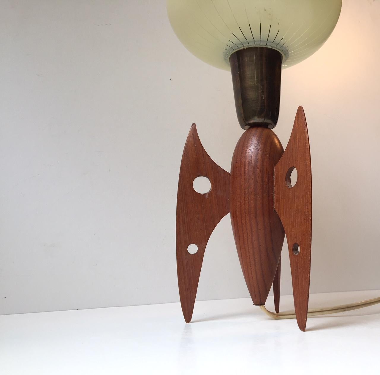 Unique professionally crafted Rocket table light. It is made of teak and has a brass supported single layered pin-striped glass shade from the period. It was made of excess furniture teak by a Scandinavian Cabinetmaker during the 1950s.