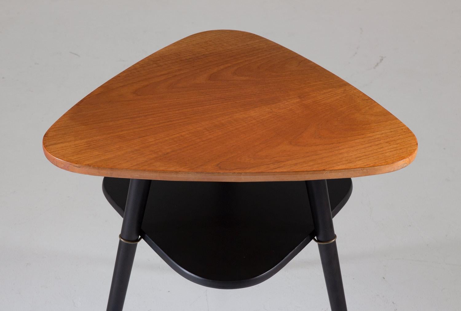 A timeless piece of Scandinavian design, the Telma side table is a must-have for fans of midcentury furniture. Designed by Nils Jonsson and produced by Hugo Troeds in Sweden, this table boasts a striking triangle-shaped tabletop of rich teak, with a