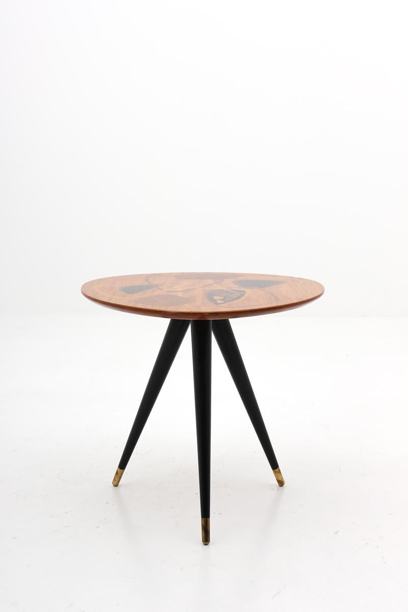 A beautifully shaped side table model 435 manufactured by H. Sundling AB, Tranås, Sweden. The triangle-shaped table-top is made of different wood inlays and the rest of the table is black lacquered with details in brass.
This table is in a very